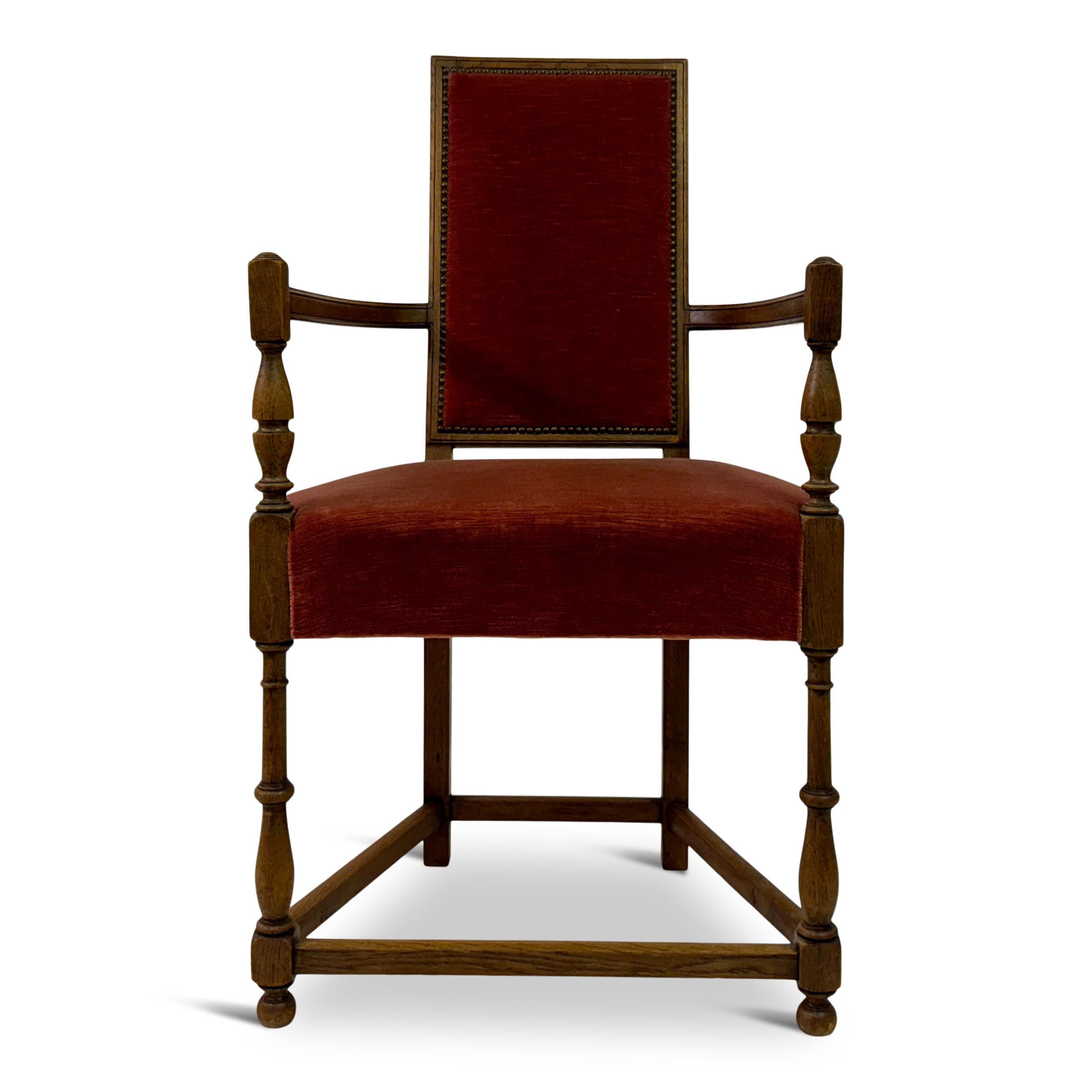 This French armchair showcases a blend of elegance and traditional craftsmanship. The chair features a sturdy oak frame, with its legs and arm supports intricately turned, adding a sense of refined detail to the piece. The backrest and seat are