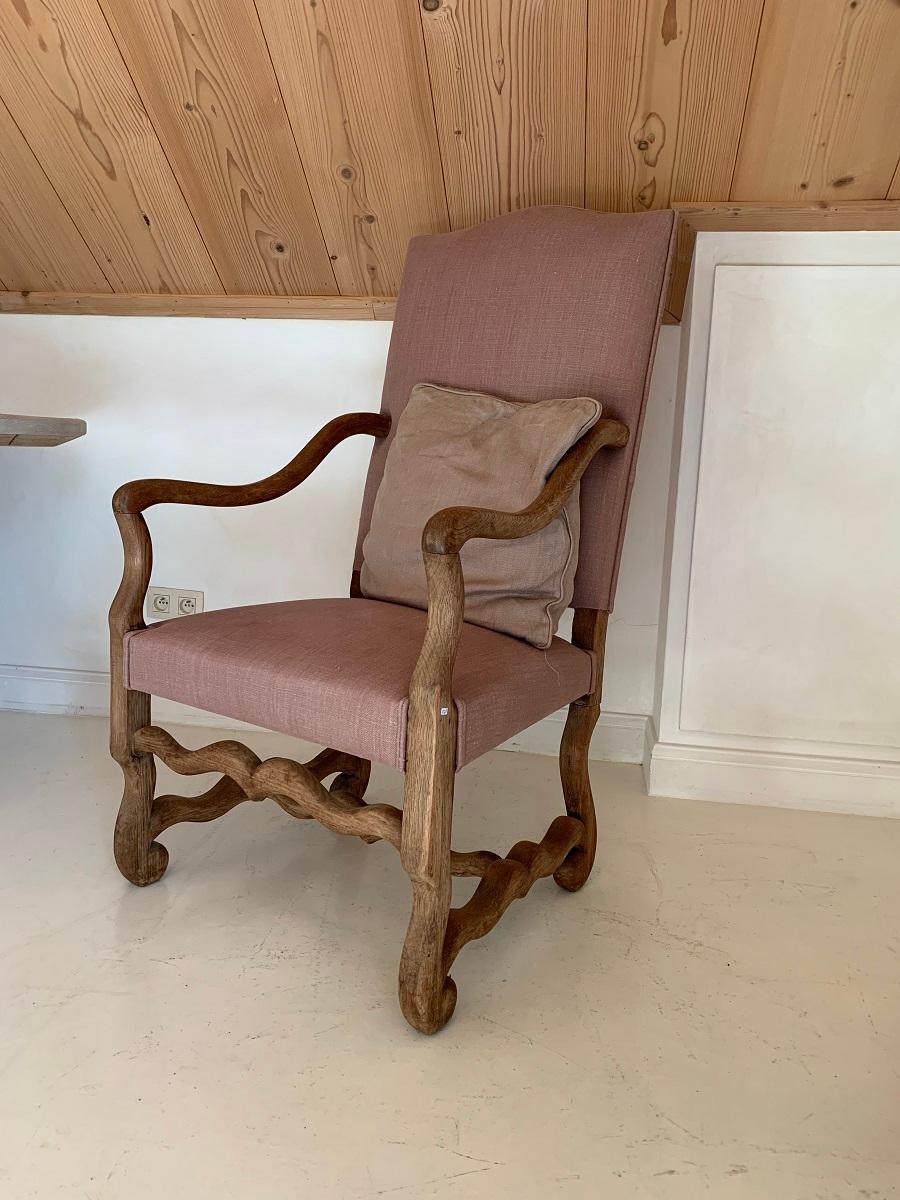 A early 20th century French armchair in oak. The model is known as 'Os de Mouton' or sheepleg shape. The original 18th century design was a Provincial take on the Louis XIV style. This chair has been reupholstered in Belgian linenn and is verry