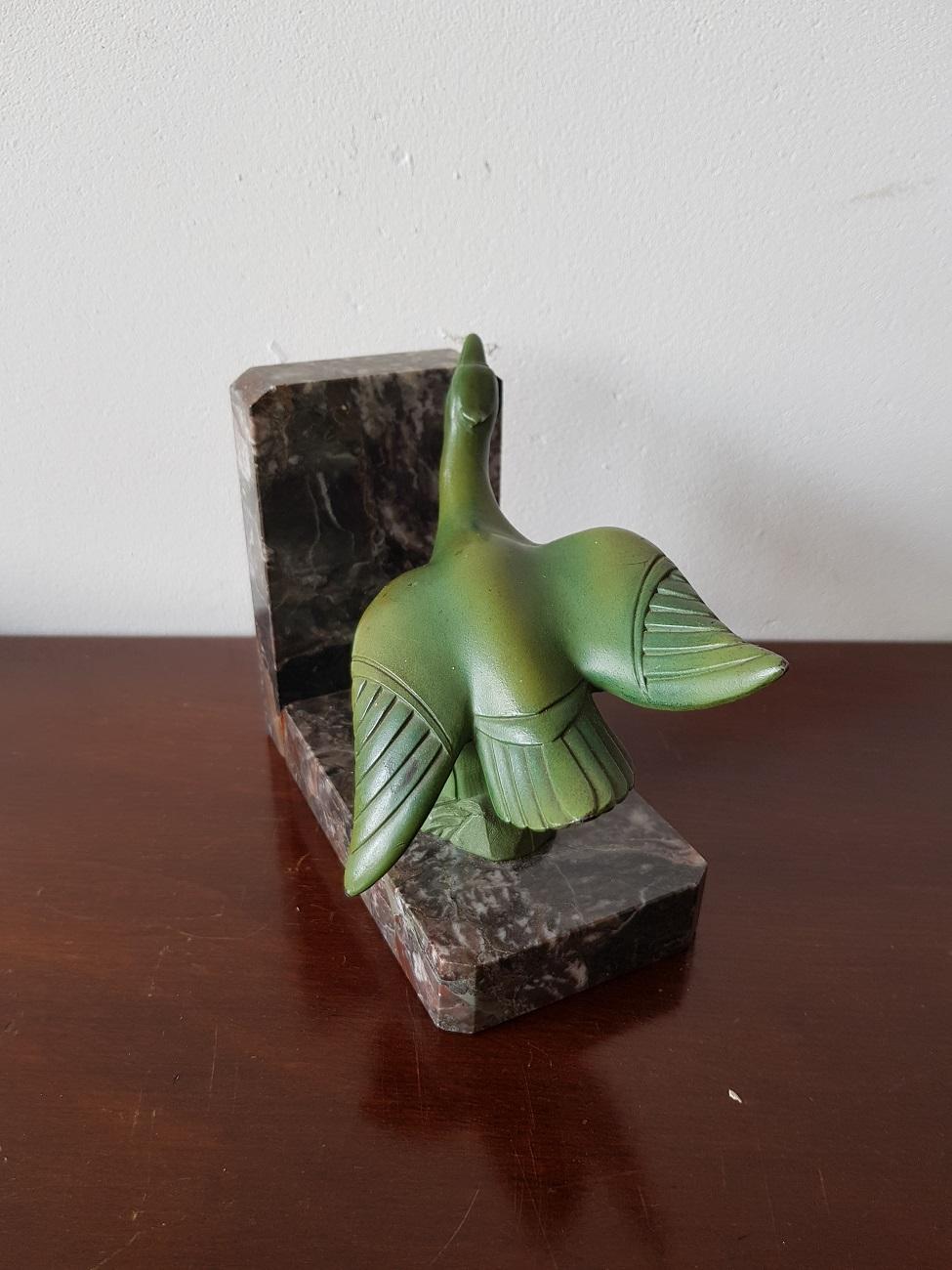 Lovely French Art Deco bookend decorated with a bronze-colored patina metal bird on gray marble, circa 1930.

The measurements are,
Depth 8.5 cm/ 3.3 inch.
Width 15 cm/ 5.9 inch.
Height 12 cm/ 4.7 inch.
 