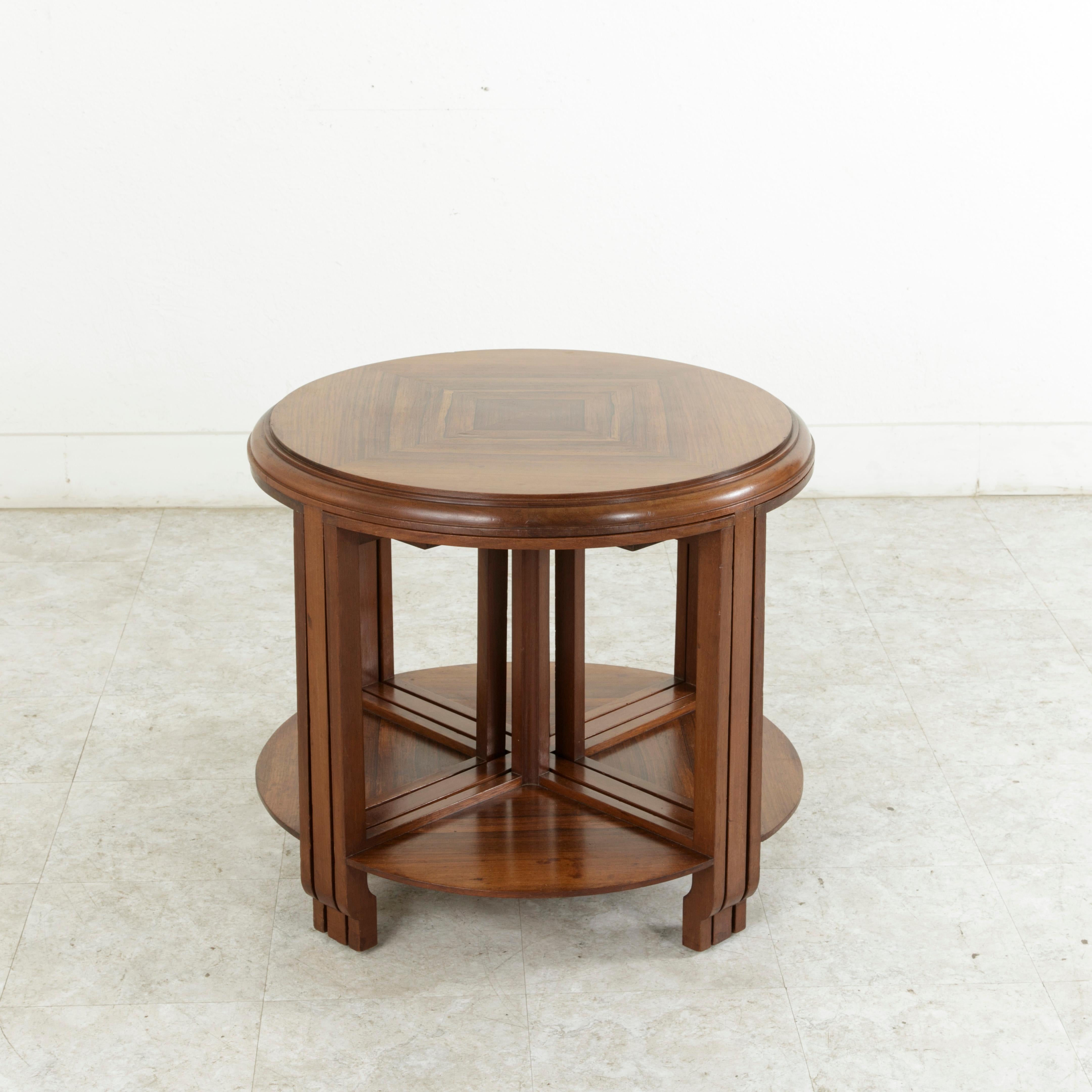 This early twentieth century French Art Deco coffee table is stamped by the French designer Louis Majorelle (1859-1926). The signature is branded inside of a shell on the underside of the tabletop. This table features a book matched palisander