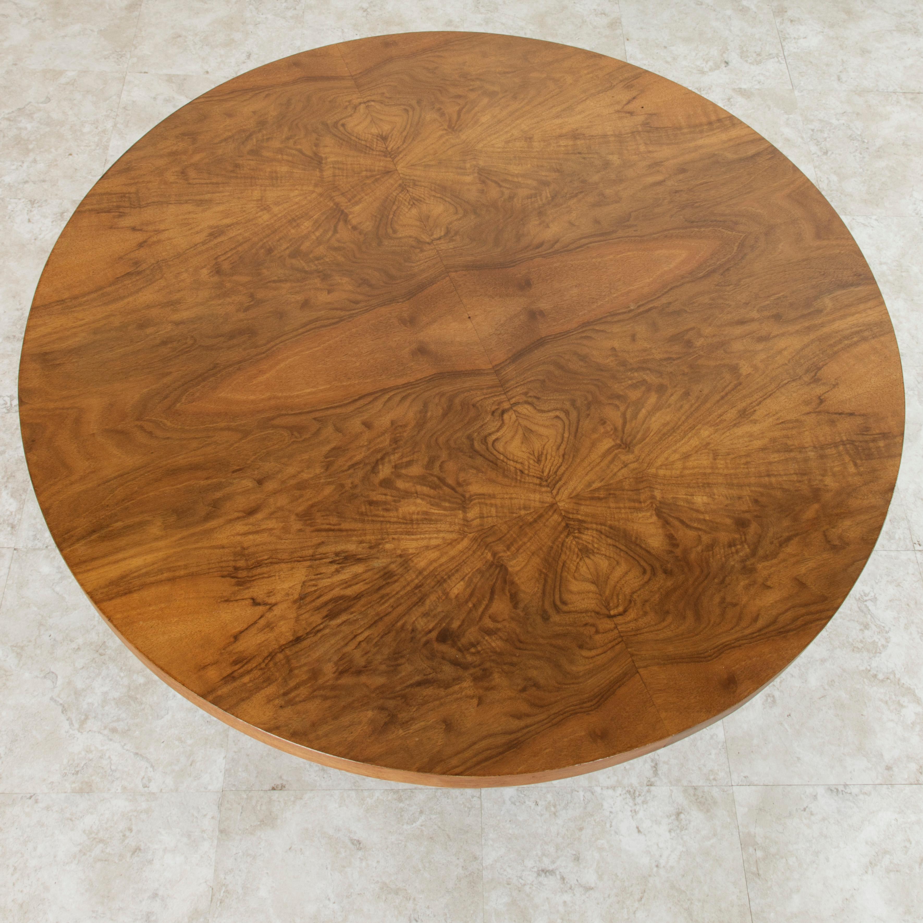 This early 20th century French Art Deco period coffee table or cocktail table features a beautiful 31.5 inch diameter bookmatched burl walnut top supported by four curved palisander legs. A fine example of Classic French Art Deco, this table was
