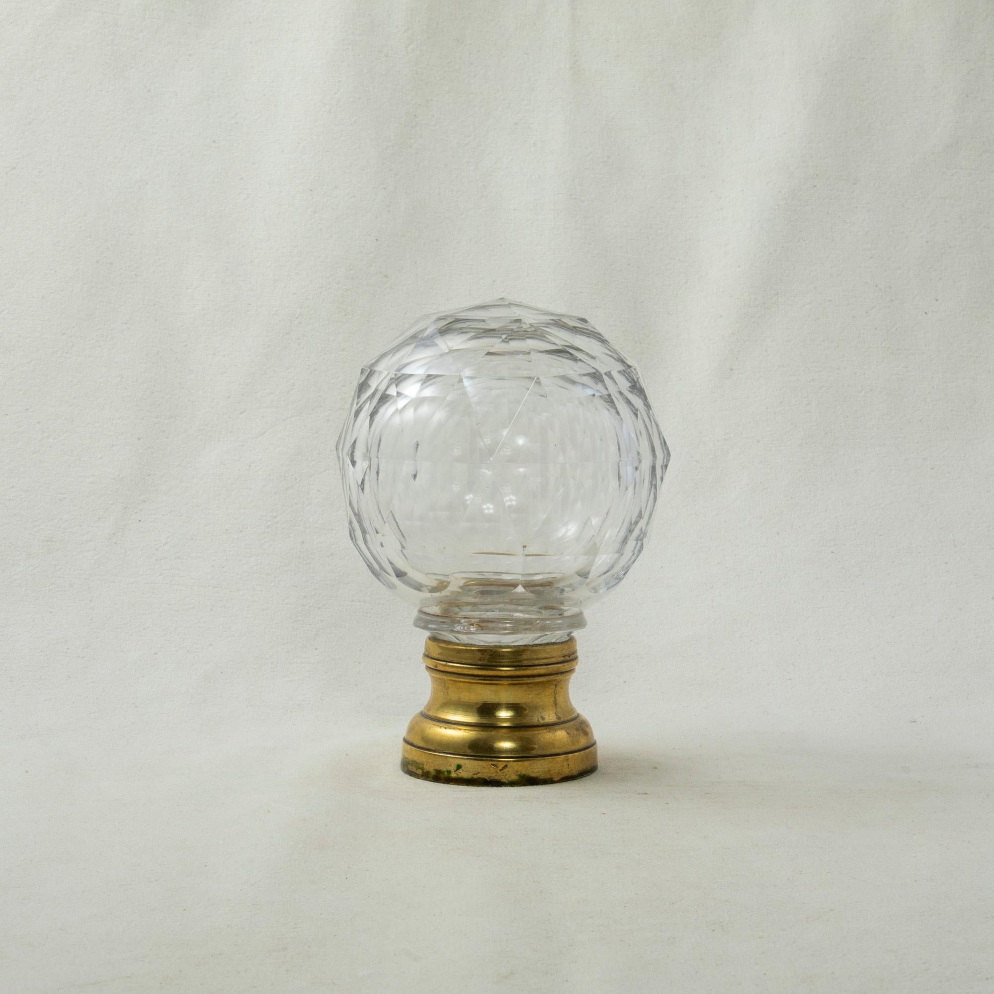 This very large early twentieth century French Art Deco period staircase finial features a multifaceted crystal ball mounted on a brass base. The base is threaded to screw onto a staircase banister for secure attachment. Standing at 5.5 inches in