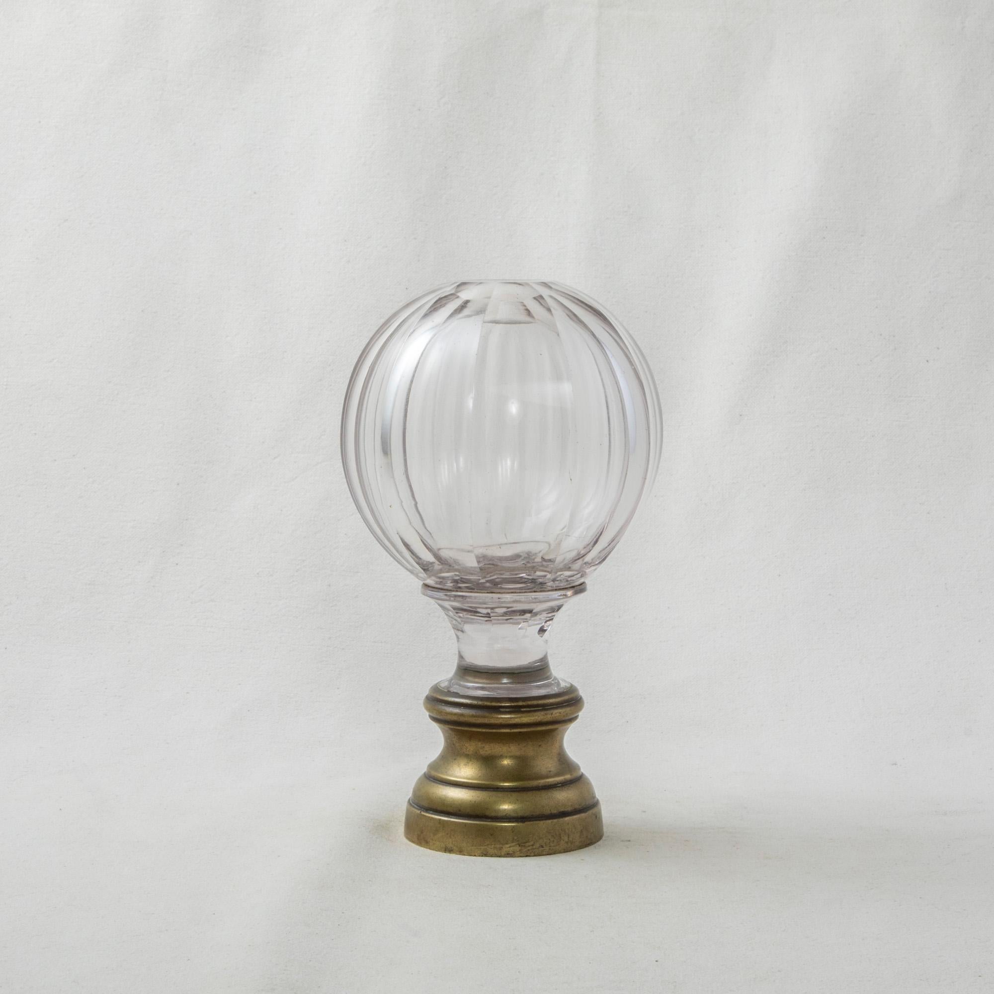 This very large early twentieth century French Art Deco period staircase finial features a multifaceted glass ball mounted on a brass base. The base is threaded to screw onto a staircase banister for secure attachment. Standing at almost seven