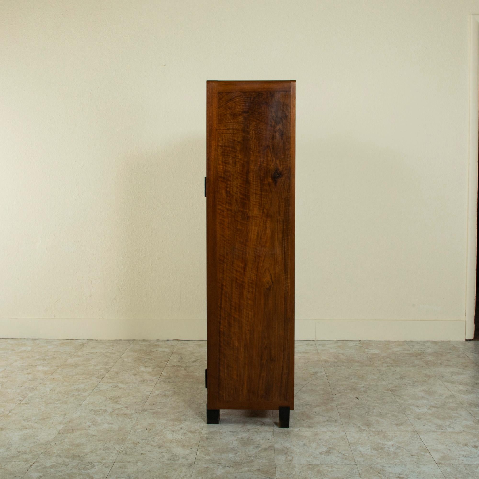 This early twentieth century French Art Deco cabinet is constructed of book matched walnut and is signed by the well known cabinet maker Maurice Alet (1874-1967). Alet began his career by studying at the Ecole des Beaux Arts in Toulouse from 1890 to