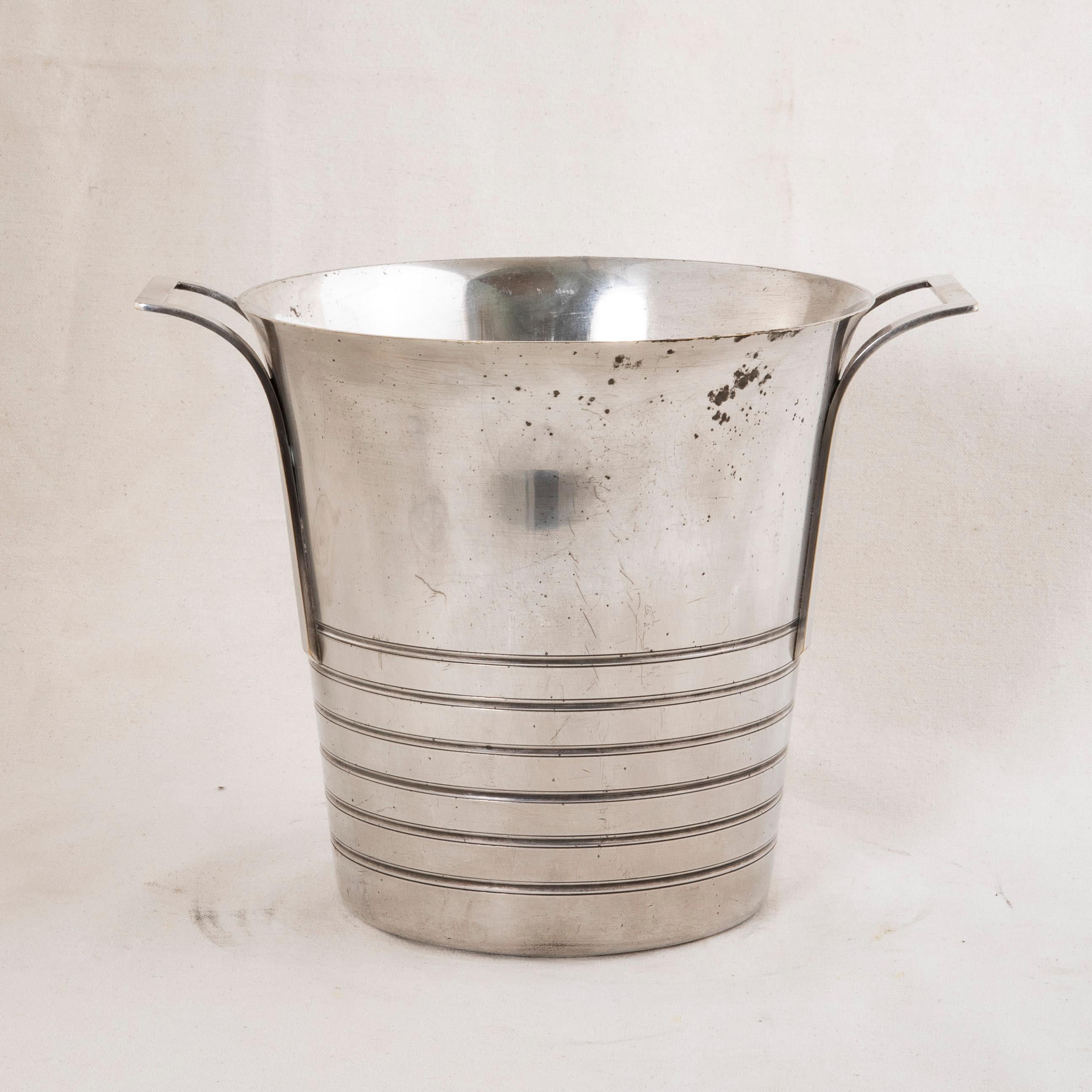 This early twentieth century French Art Deco Period silver plate champagne bucket features concentric circles around the bottom. Two squared handles allow for easier carrying. The bottom is stamped with the maker's hallmark and the number 18. The