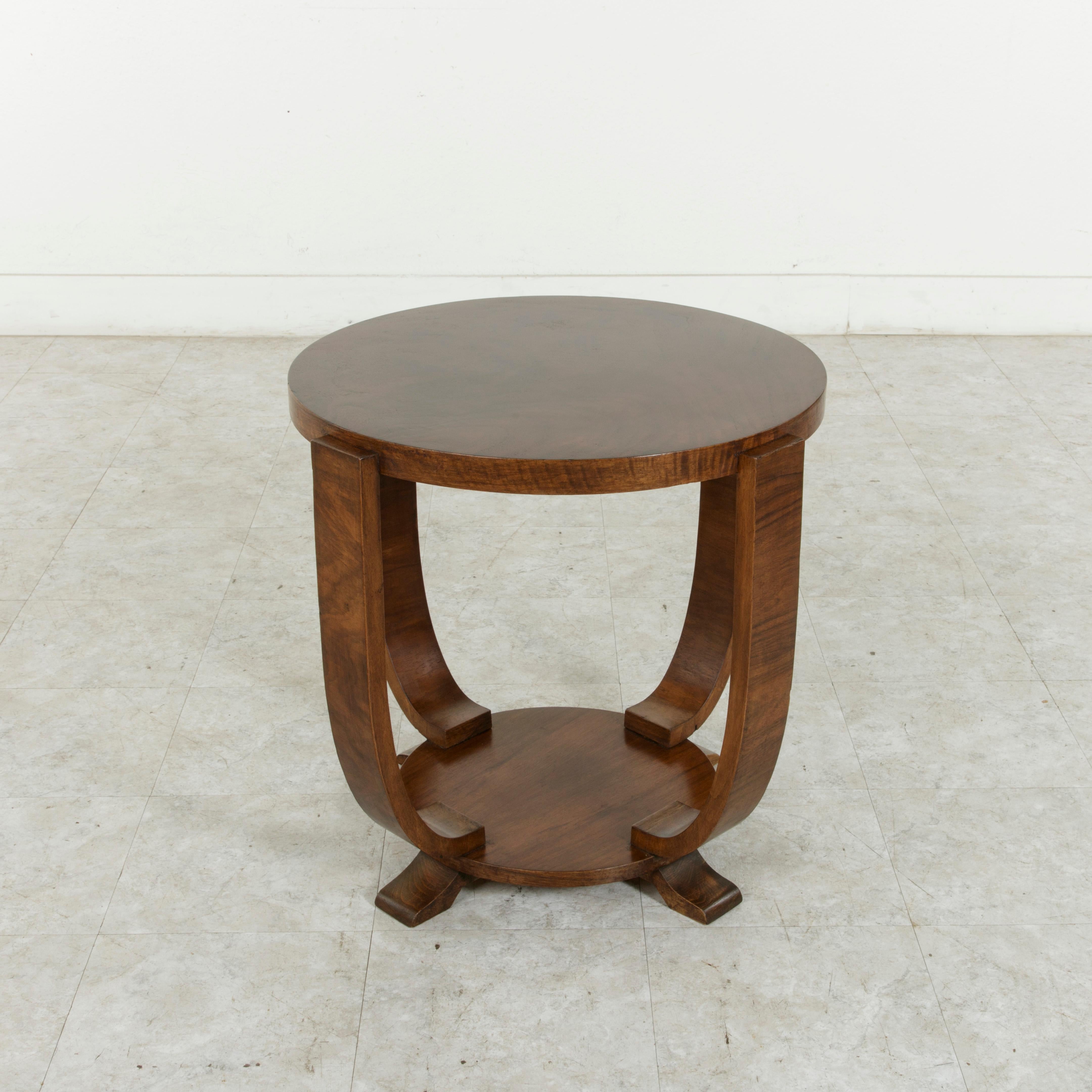 This early 20th century French Art Deco period side table boasts a solid walnut top supported by four curved legs that rest on a solid walnut base. A fine example of Classic French Art Deco, this table was found in the Languedoc region of Southern
