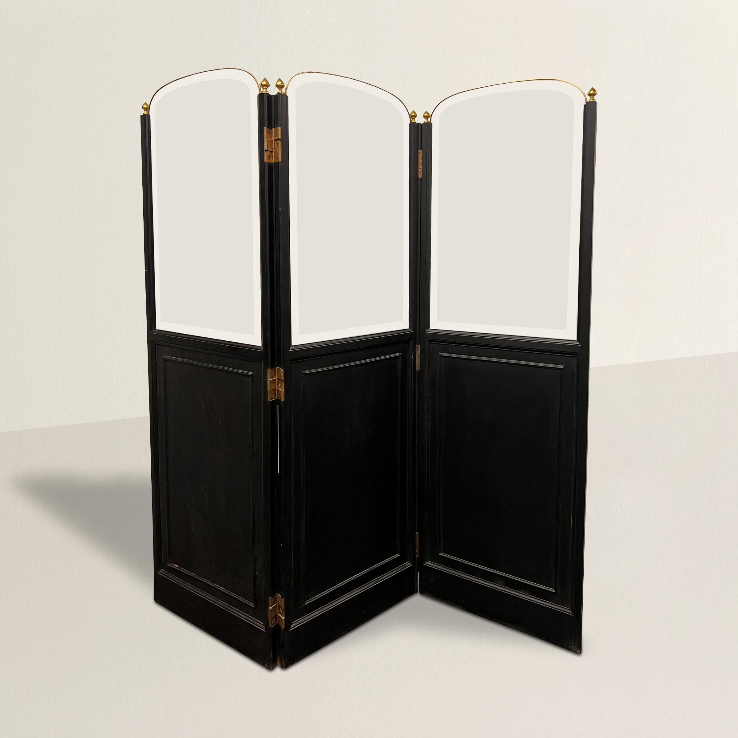 A chic and spectacular early 20th century French Art Nouveau folding screen with three beautifully arched and beveled glass panels held in place with brass frames and brass finials, and with black painted beveled wood panels.  Double action brass