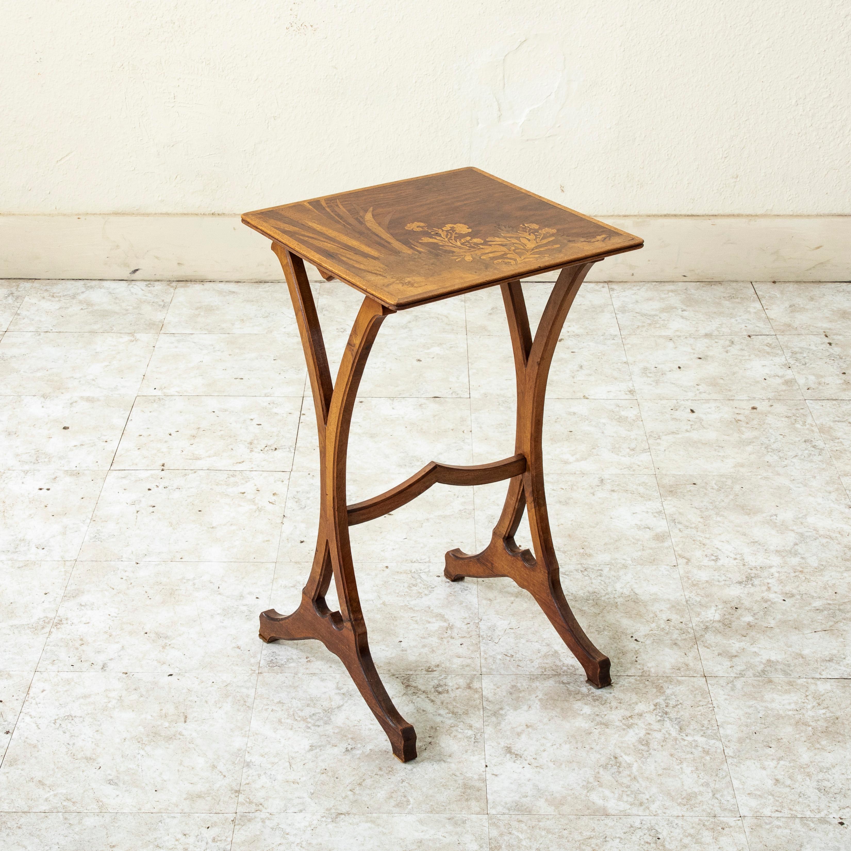 This French Art Nouveau period walnut side table from the turn of the twentieth century is signed by the renowned artist Galle (Emile Galle 1846-1904). The tabletop features intricate inlay in lemonwood and rosewood of leaves and flowers. The table