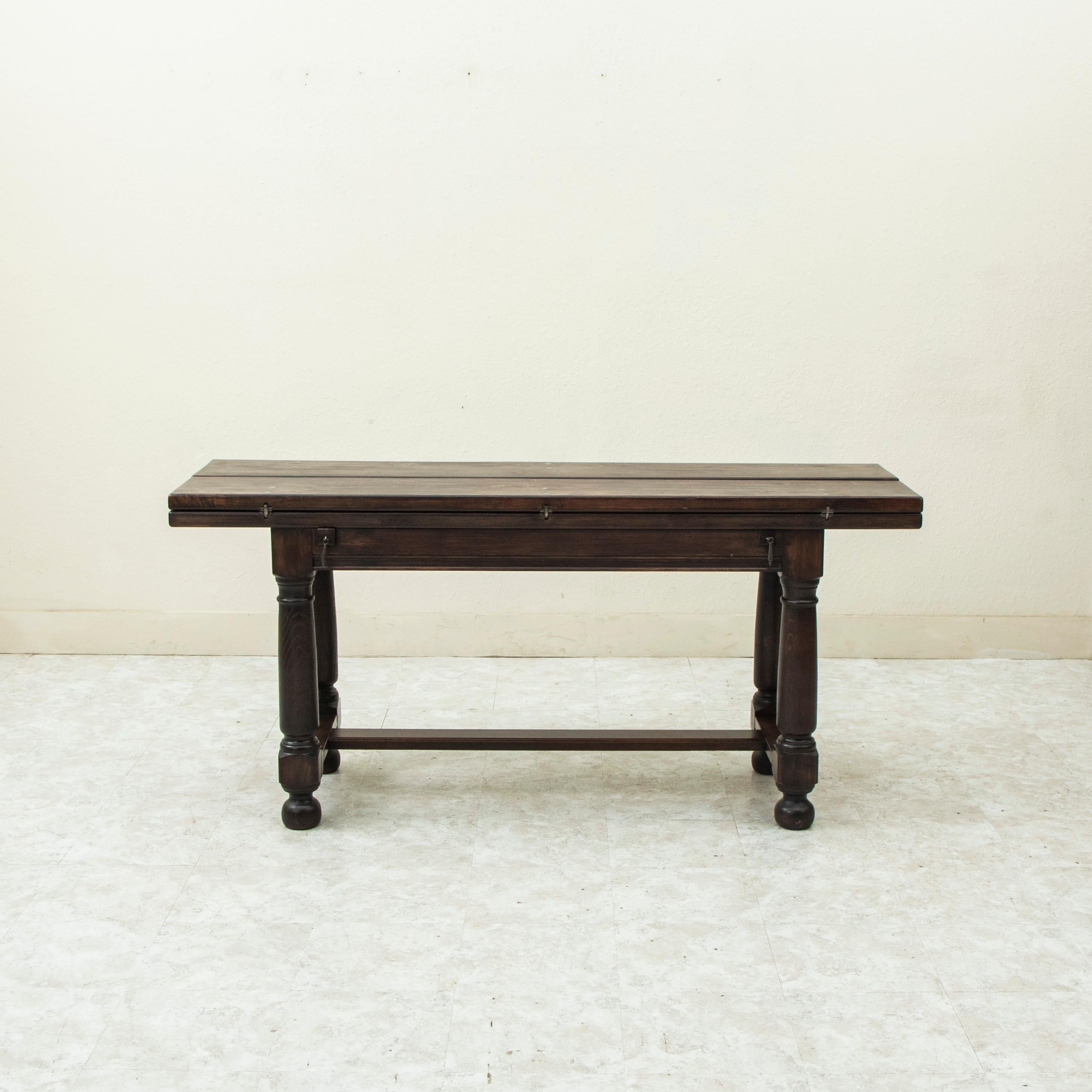 Called a table de chasse in French, or hunt table, this French chestnut table from the early twentieth century was originally designed to lay out the game after the hunt and features a hinged top that allows the surface to double in width when