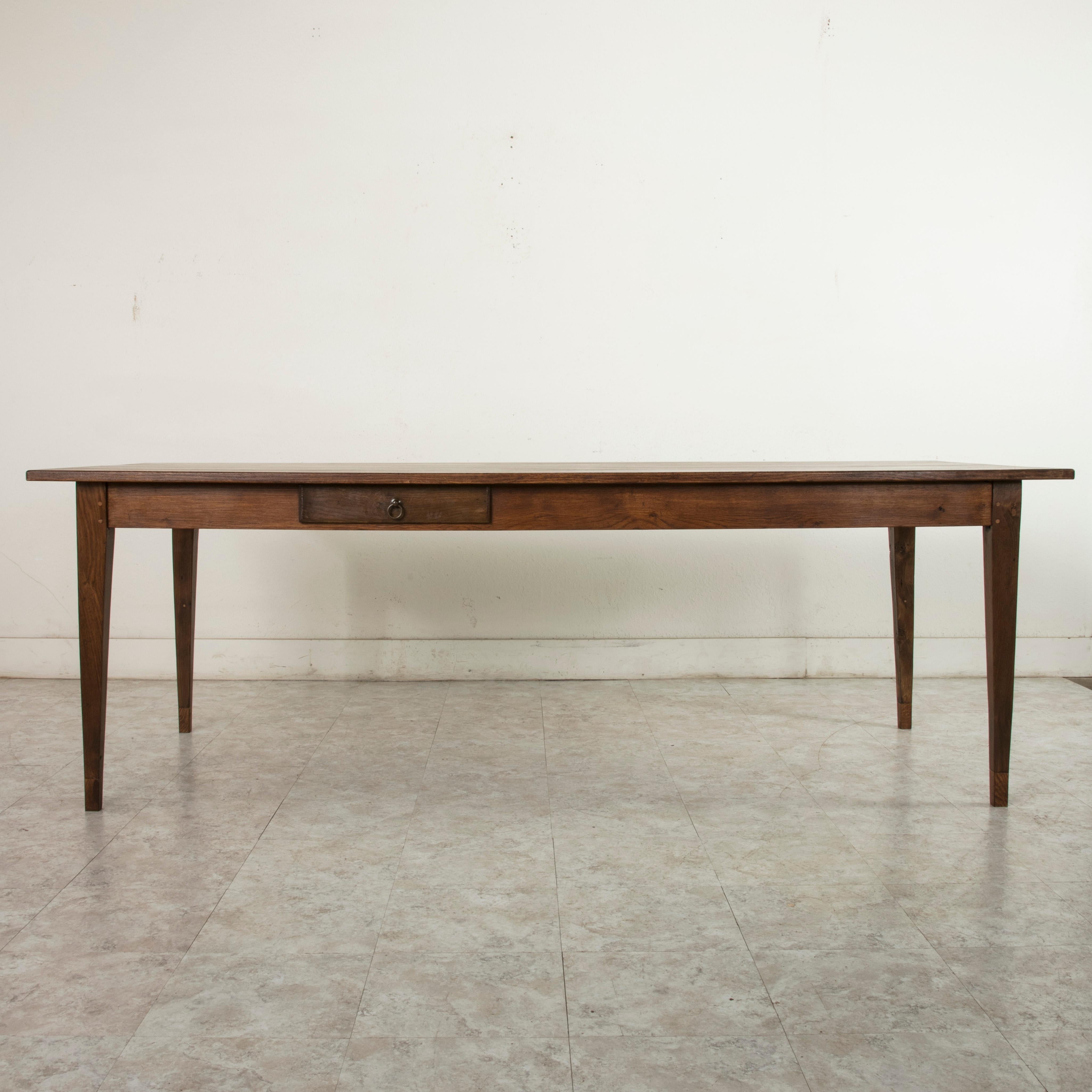 Originally from a farm in the l'Orne region of Normandy, France, this early 20th century artisan-made oak farm table features hand pegged construction. Its top measures nearly 90 inches long and rests on four gently tapered square legs. A single