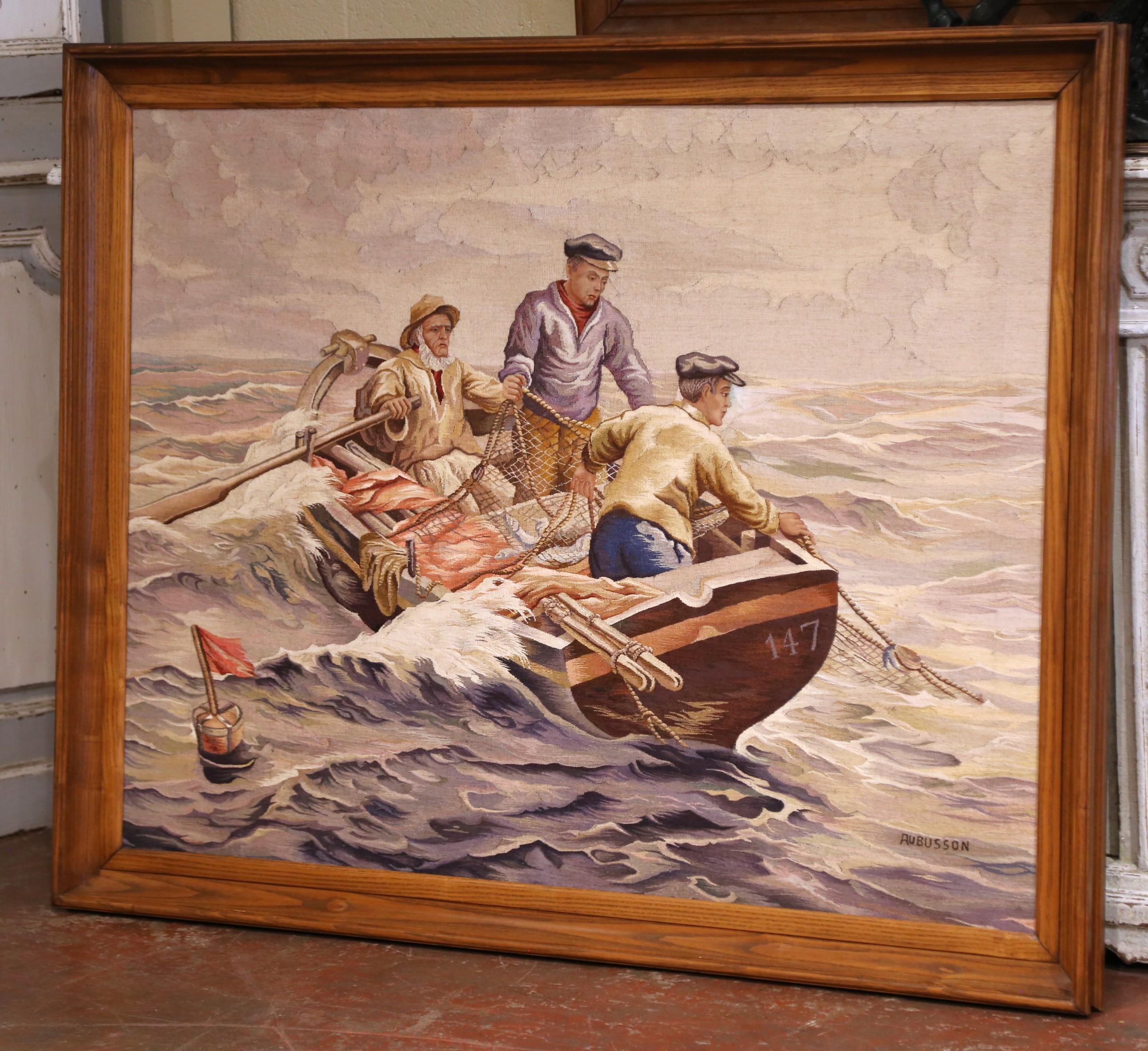 Este tapiz francés tejido a mano de principios del siglo XX, realizado hacia 1920, representa una dramática escena marítima de tres pescadores que navegan por aguas agitadas mientras echan las redes desde una pequeña barca de madera marcada con el