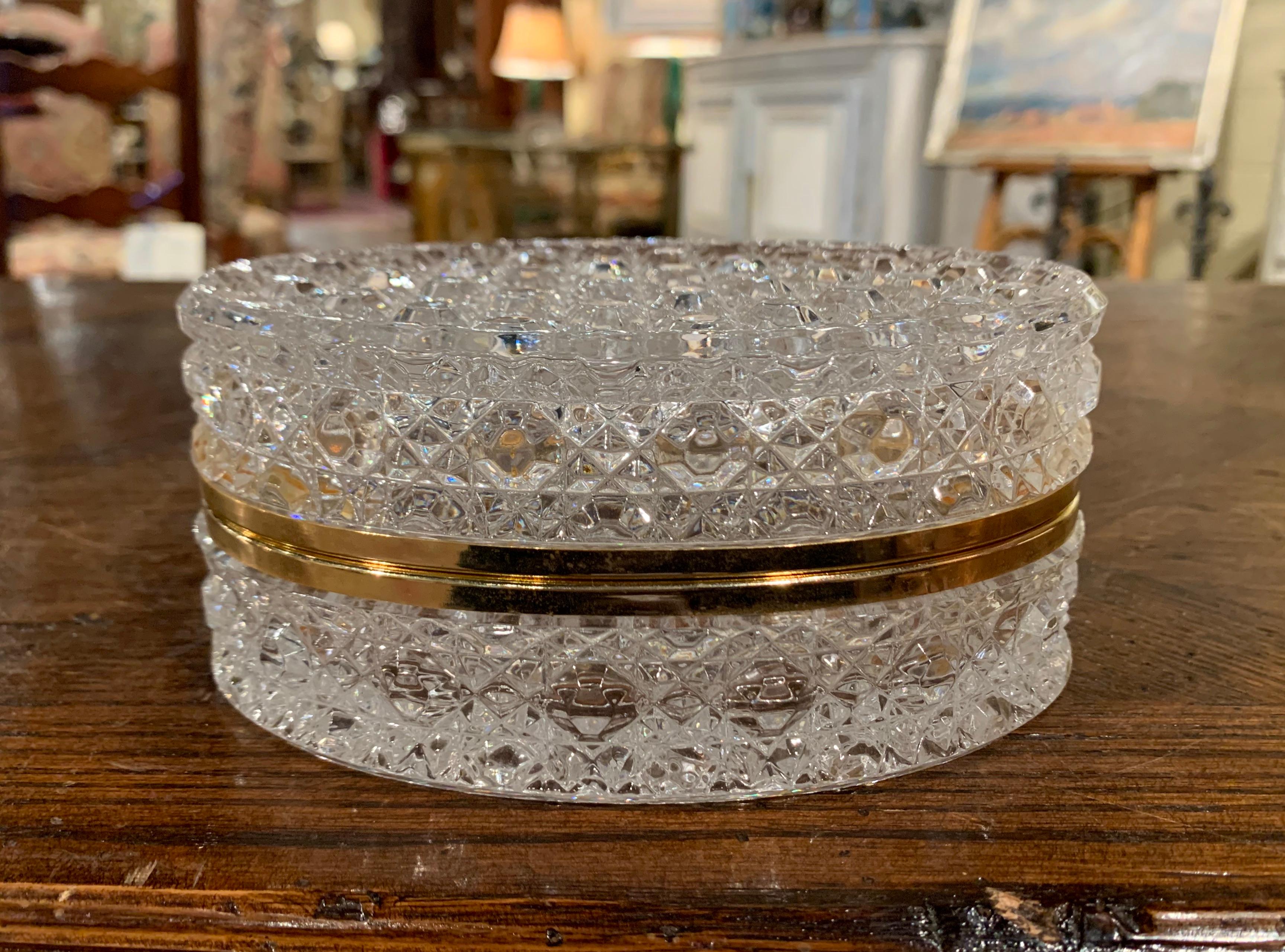 Keep your jewelry or other valuables in this delicate Baccarat style antique box; crafted in France circa 1920, the cut glass box is oval in shape, and features a decorative brass rim opening to reveal inside storage. The box in in excellent