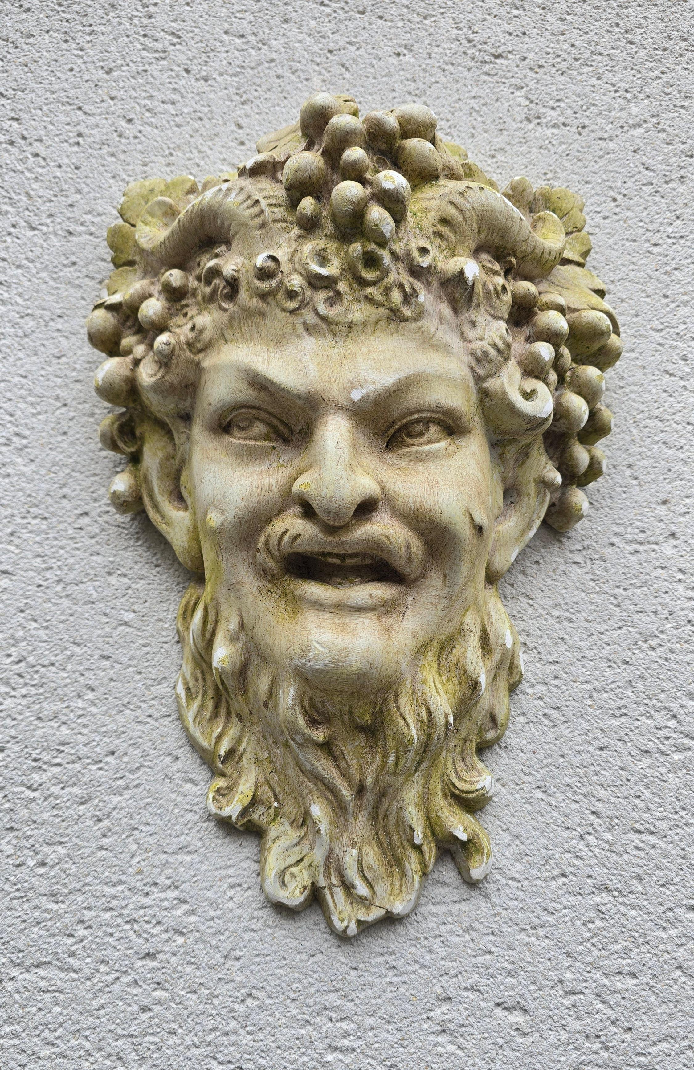 Masque mural Bacchus en plâtre, France vers 1900-1930. Surface magnifiquement vieillie avec une patine naturelle de mousse, représentant le dieu romain du vin couronné de raisins et de feuilles de vigne. Un accent décoratif frappant pour le jardin