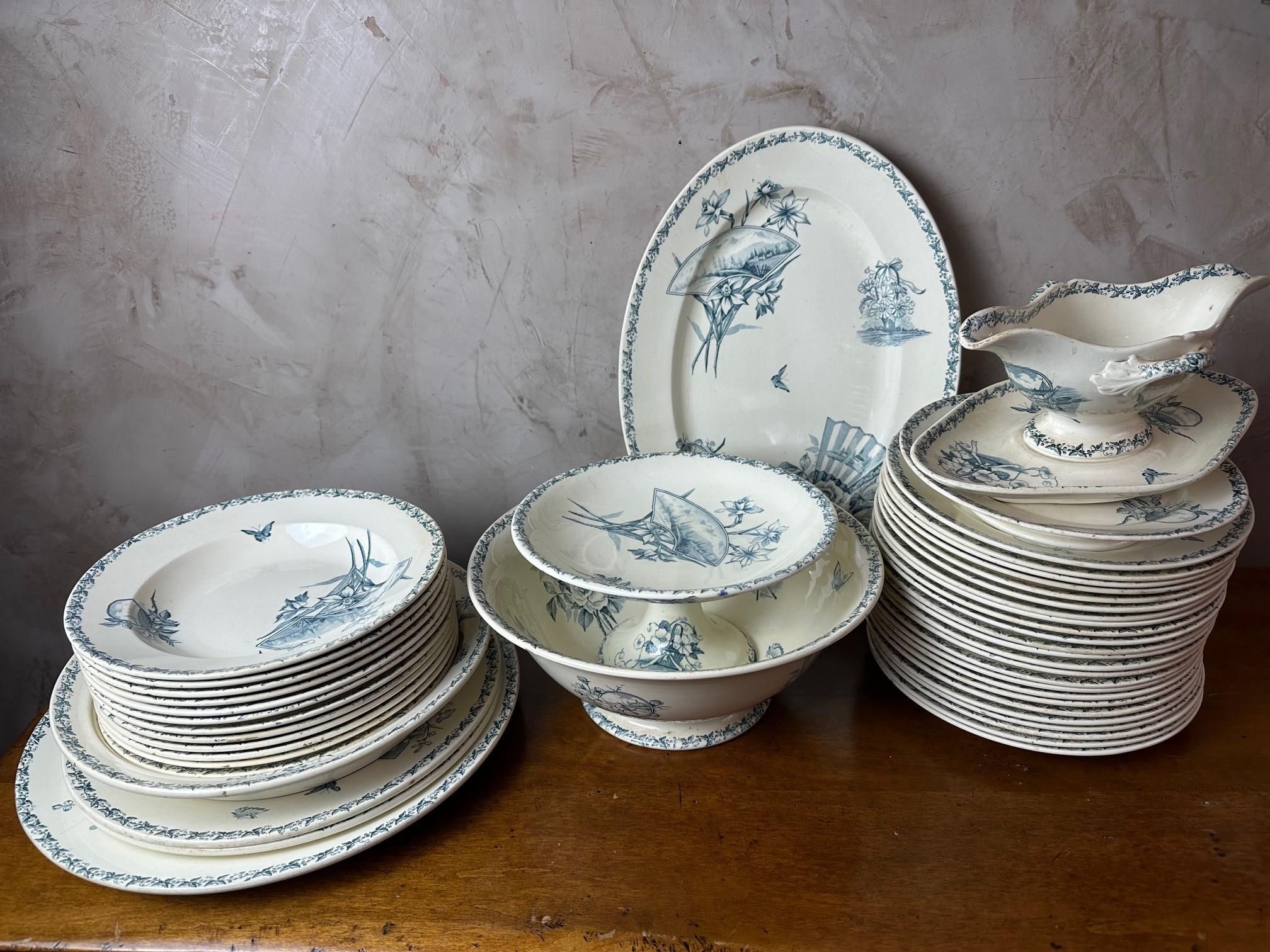 Très beau service de table en faïence bleue et blanche datant du début du XXe siècle (1900) et signé par la manufacture française Badonviller.

Belle décoration d'oiseaux, de papillons, d'éventails et de paysages.

Ce service est composé de :

24