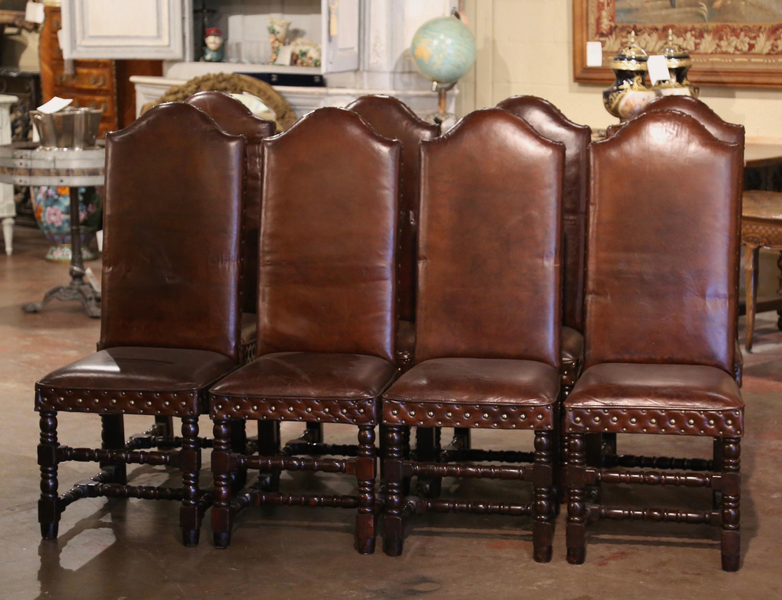 Dress a dining or breakfast table with this elegant suite of 8 side chairs! Crafted in southern France circa 1920 and built of walnut, each antique chair stands on carved turned legs decorated with a bottom stretcher; each seating features a tall