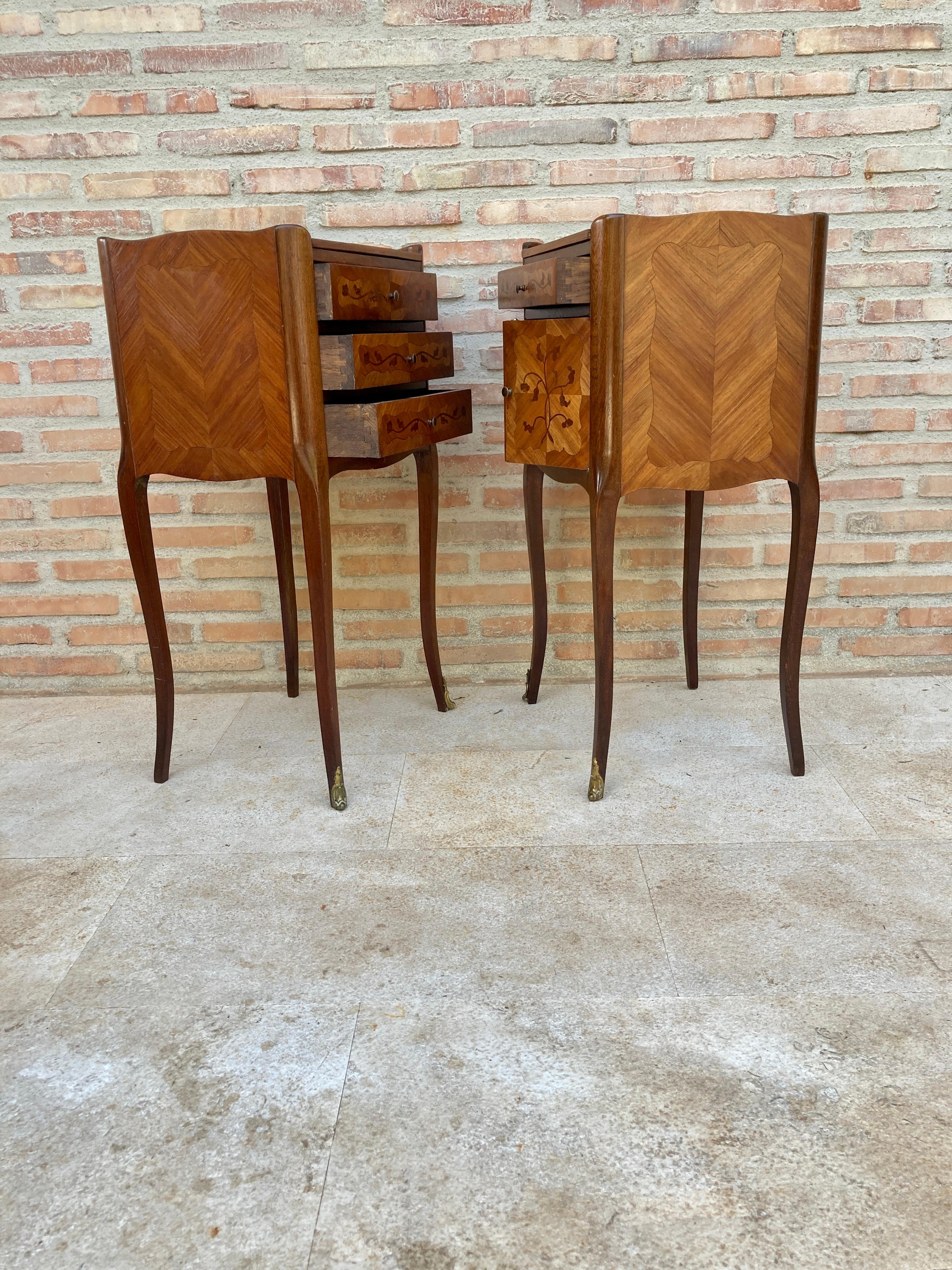 Matching Louis XV style kingwood bedside tables, distinguished from each other because one has three drawers and the other has a drawer and a front door, with floral marquetry on the top and front. The pieces retain their original and beautiful