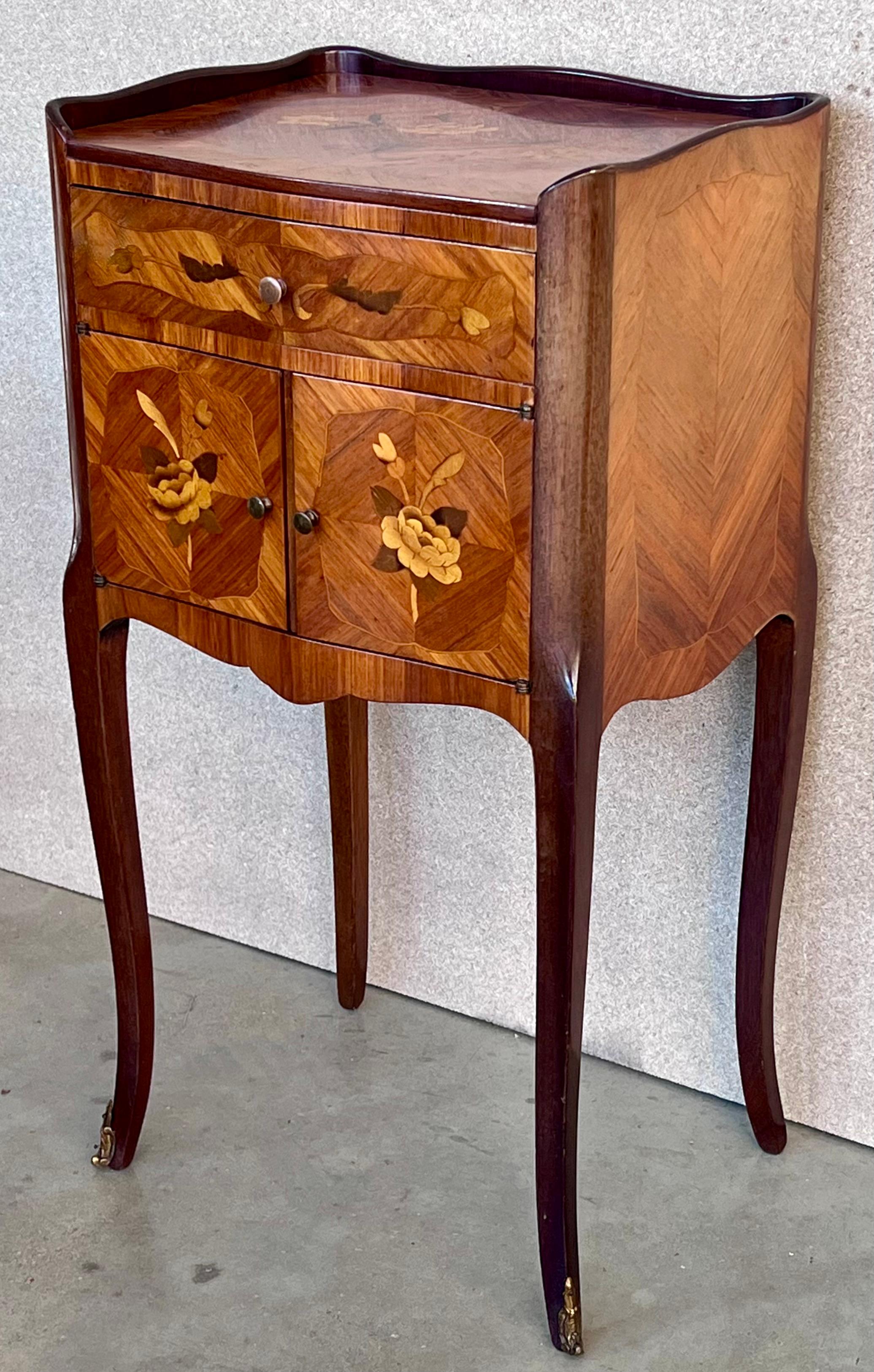 Louis XV style kingwood bedside tables with a drawer and a front door, with floral marquetry on the top and front. The pieces retain their original and beautiful floral marquetry covers and are adorned with highly decorative and finely detailed