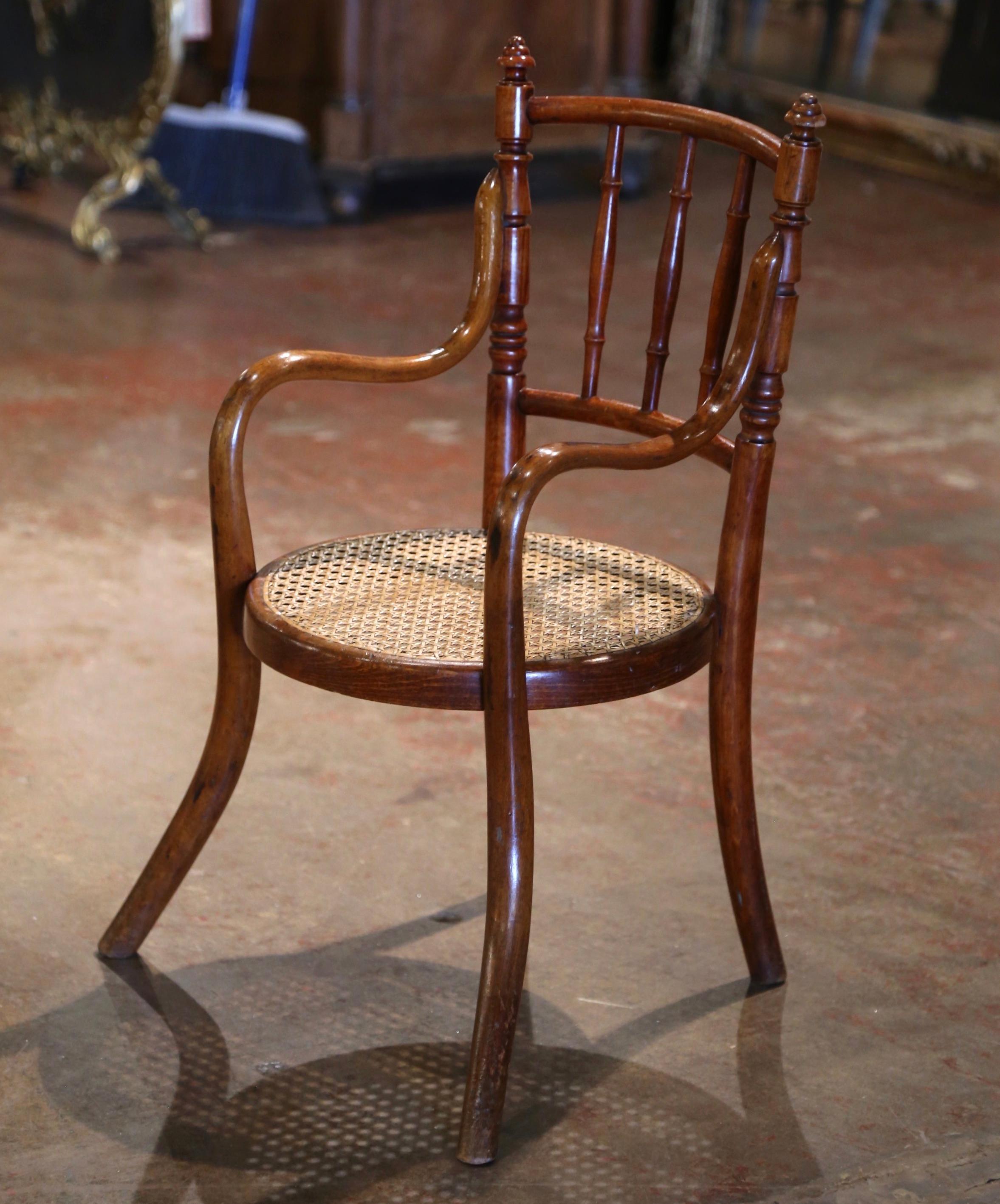 Decorate a kid's room with this antique Art Deco child armchair. Crafted in France circa 1920 in the matter of Michael Thonet, and built of bentwood, the baby chair stands on four curved legs; it features a double rounded ladder back dressed with
