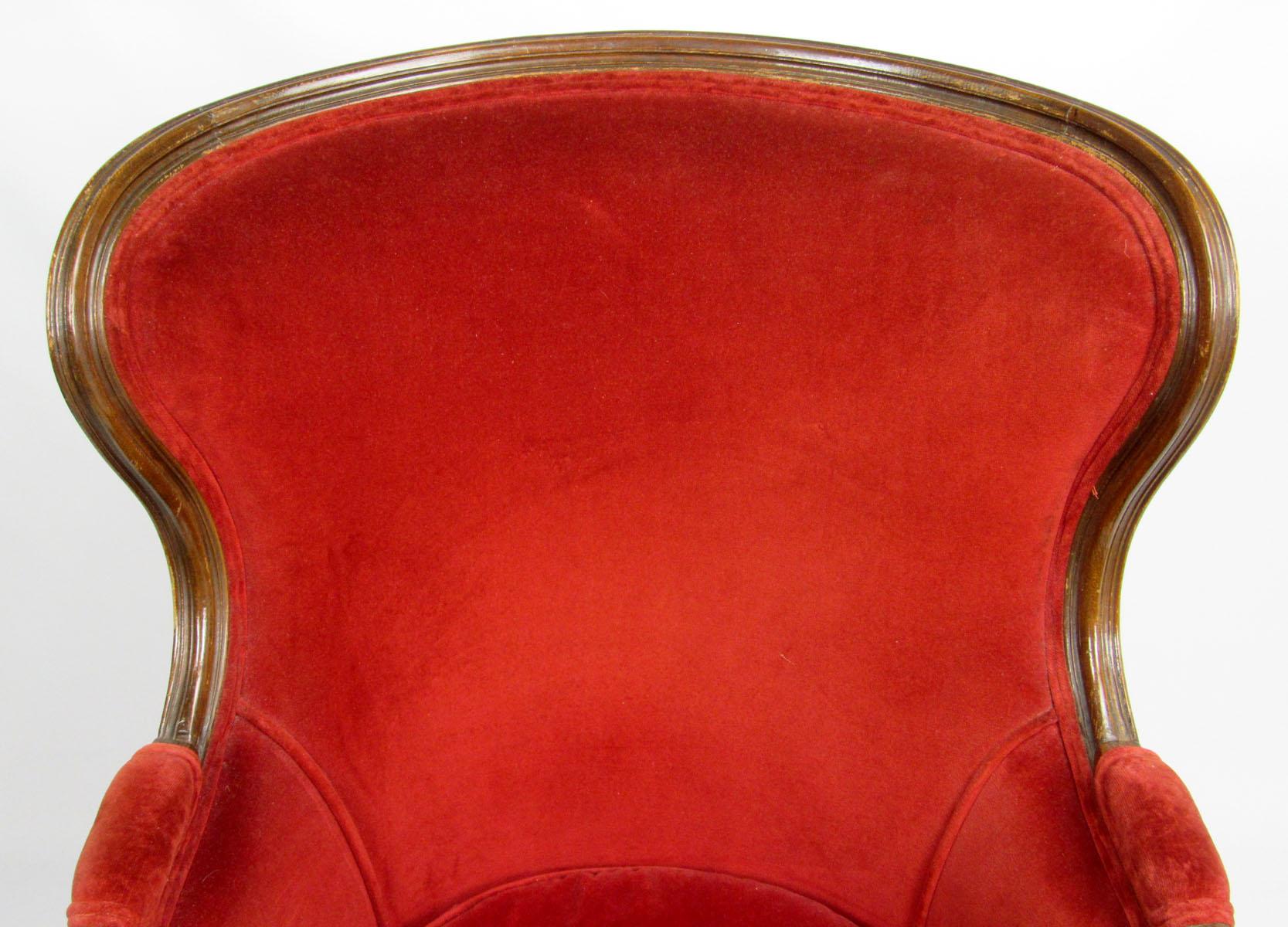 Early 20th century French bergère carved from beechwood and upholstered in red velvet with detached cushion.