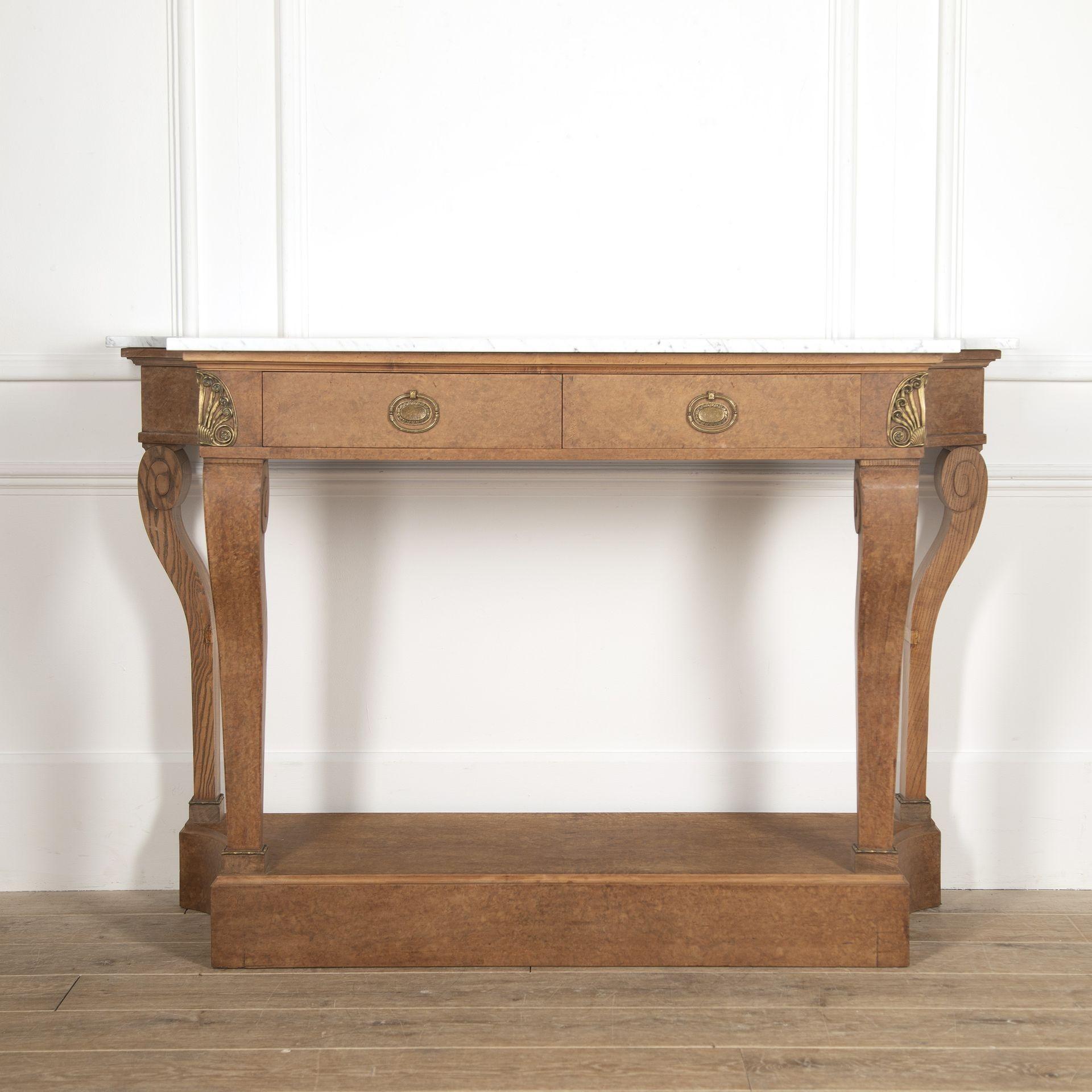Very elegant early 20th Century French birds-eye maple console table. This pretty console features a shaped white Carrara marble top over two frieze drawers with decorative handles and ormolu mounts to either side. Supported on tapering front
