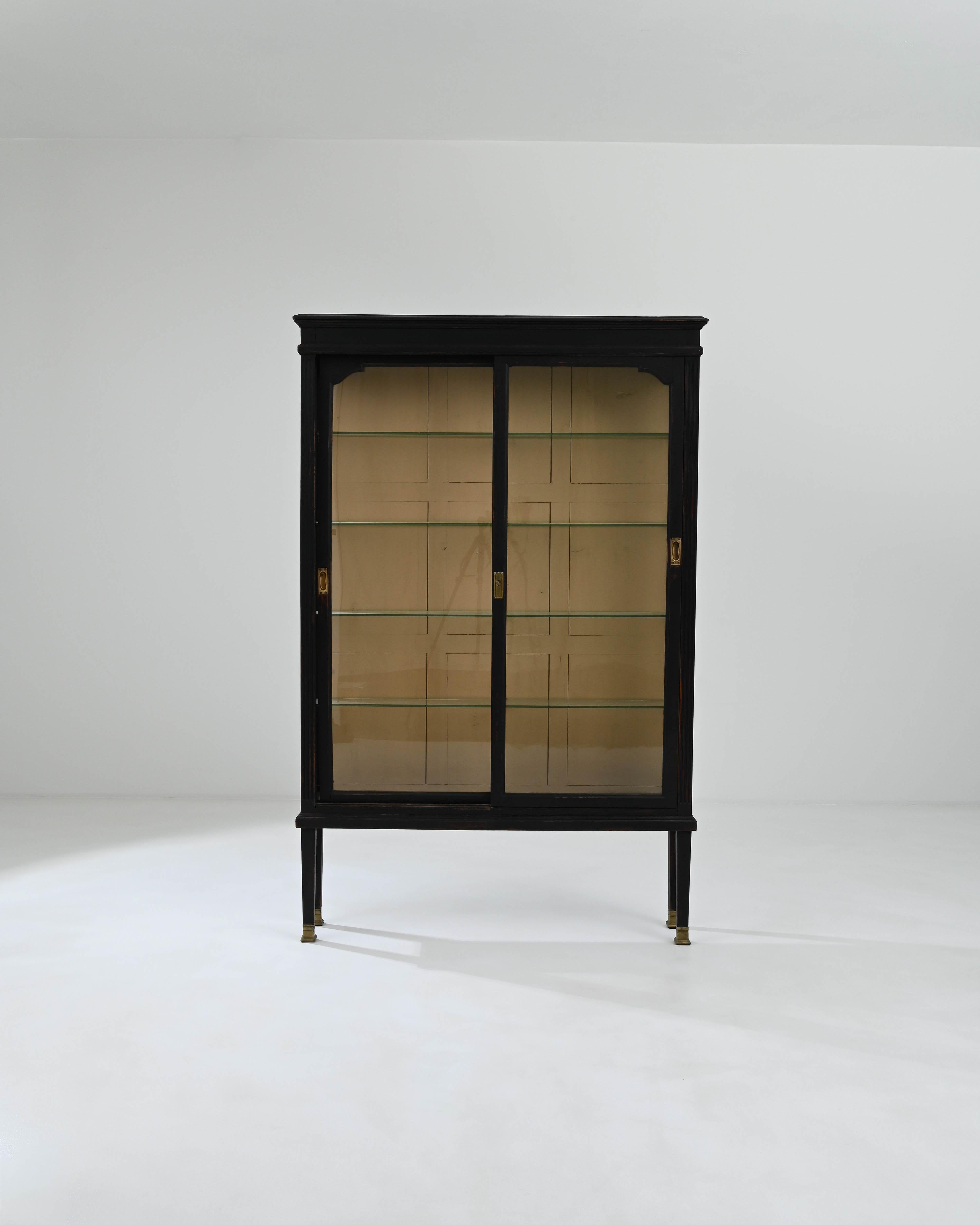 The graceful form and attractive patina of this vintage wooden vitrine make it an ideal display case for precious objects. Built in France in the early 20th century, the design incorporates the stylish simplicity of Modernist design with the elegant