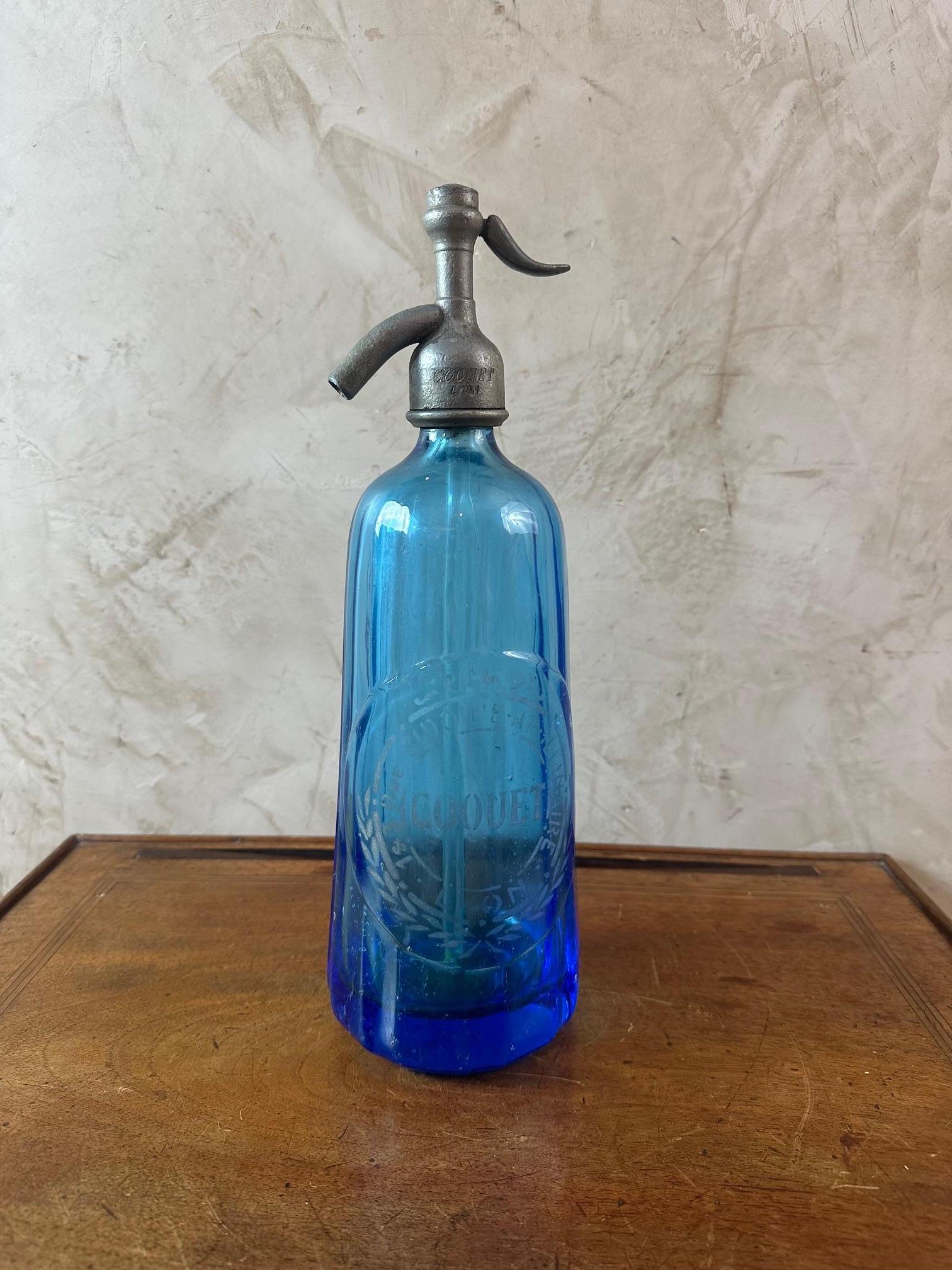 Very beautiful French blue siphon bottle dating from the beginning of the 20th century in good condition.
Created for the Coquet house in Lyon 1&3 rue Sidoine Apollinaire.
Thick serrated glass of very good quality.
Siphon in tin 1st title made by