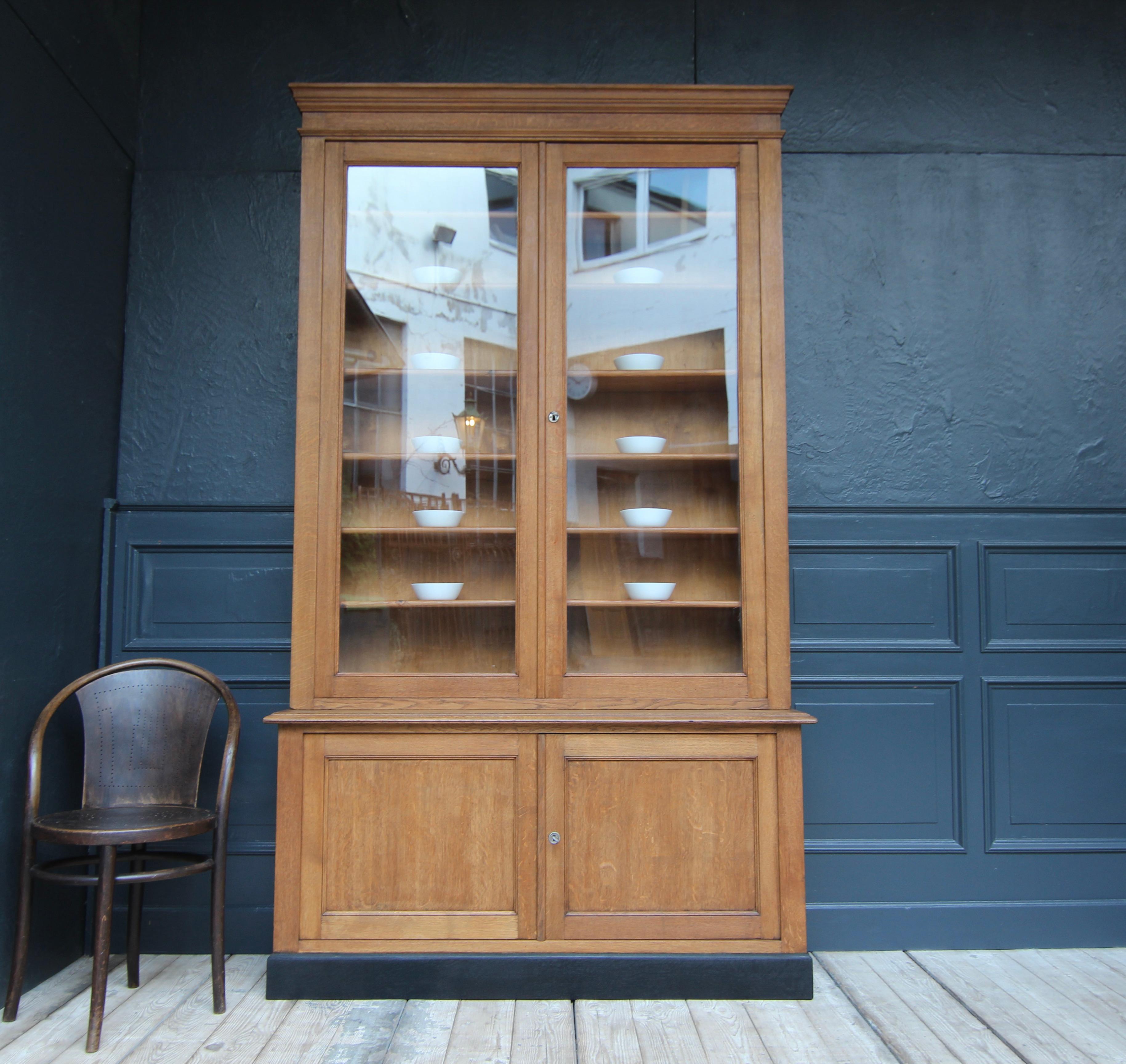 French bookcase or display cabinet from the shop fittings of a pharmacy. Around 1910.

A rare original in a classic timeless design with great proportions.

 
Straight-lined four-door body in oak, consisting of a base cabinet standing on an ebonised