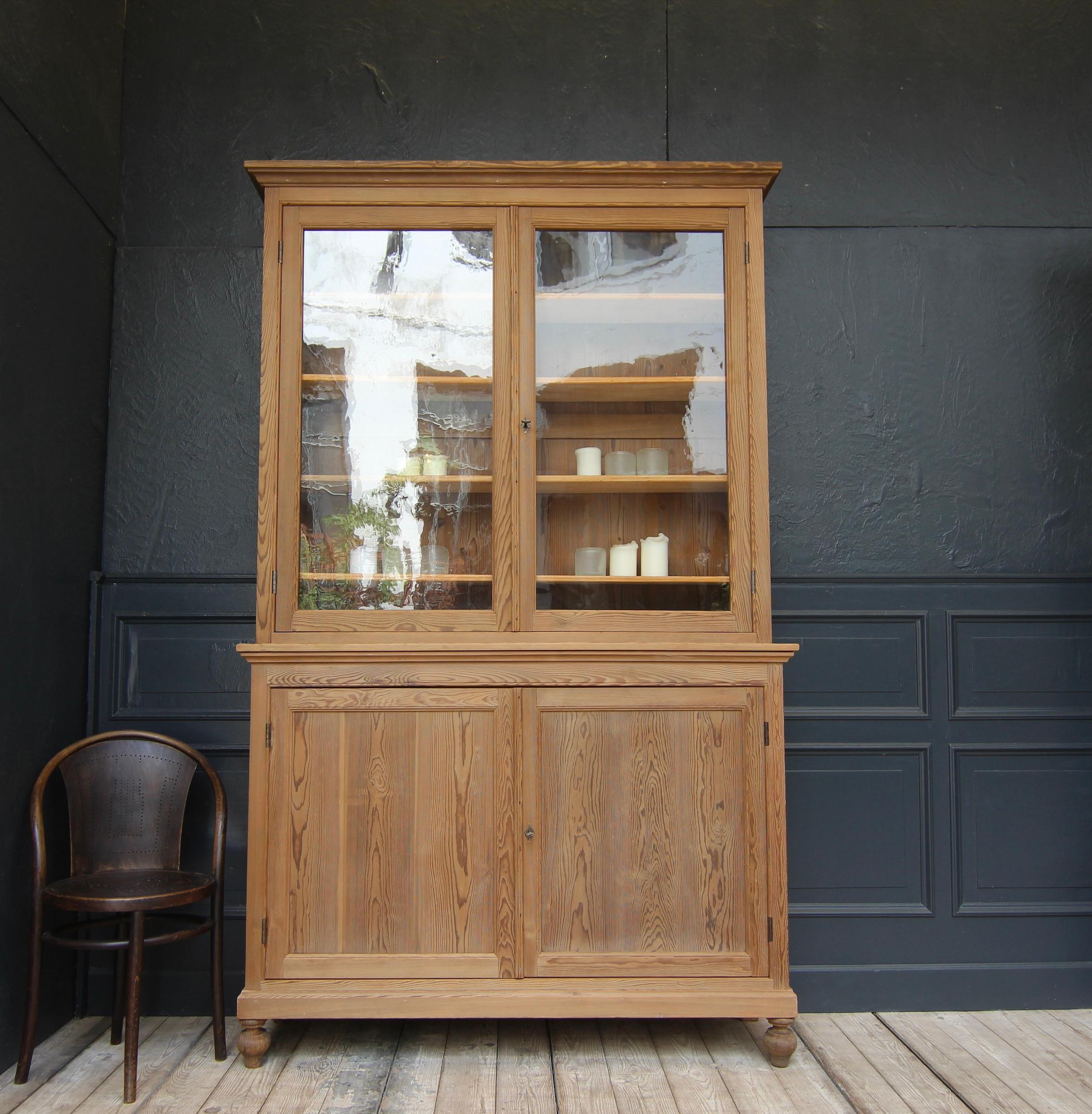 French display cabinet or bookcase from around 1900. Made of solid pine wood.

Two-part, side-moulded 
