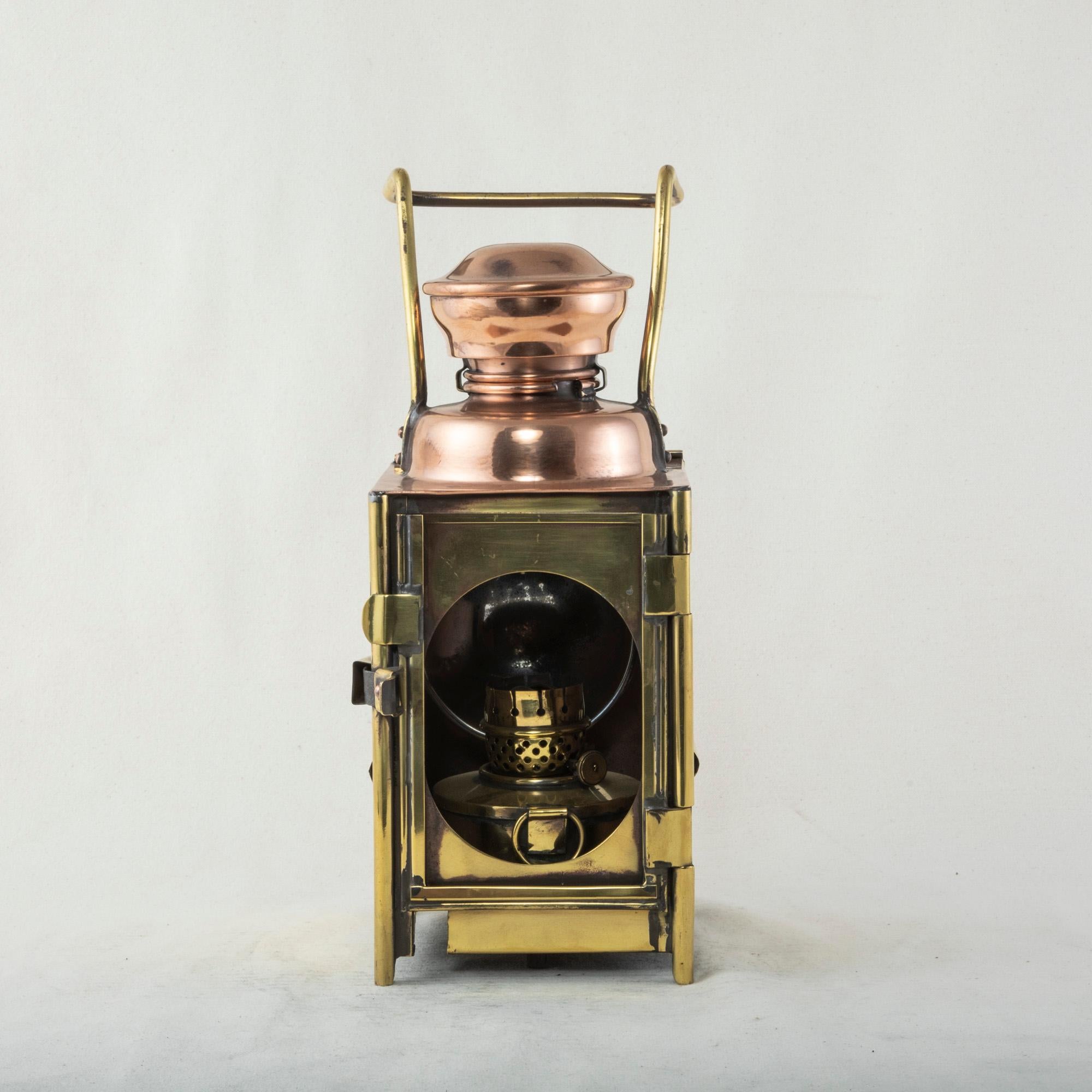 This French brass and copper railroad lantern from the early twentieth century is marked on the side SNCF (Societe Nationale des Chemins de Fer), the national railroad company of France. The lantern is capped with copper and has a door on one side