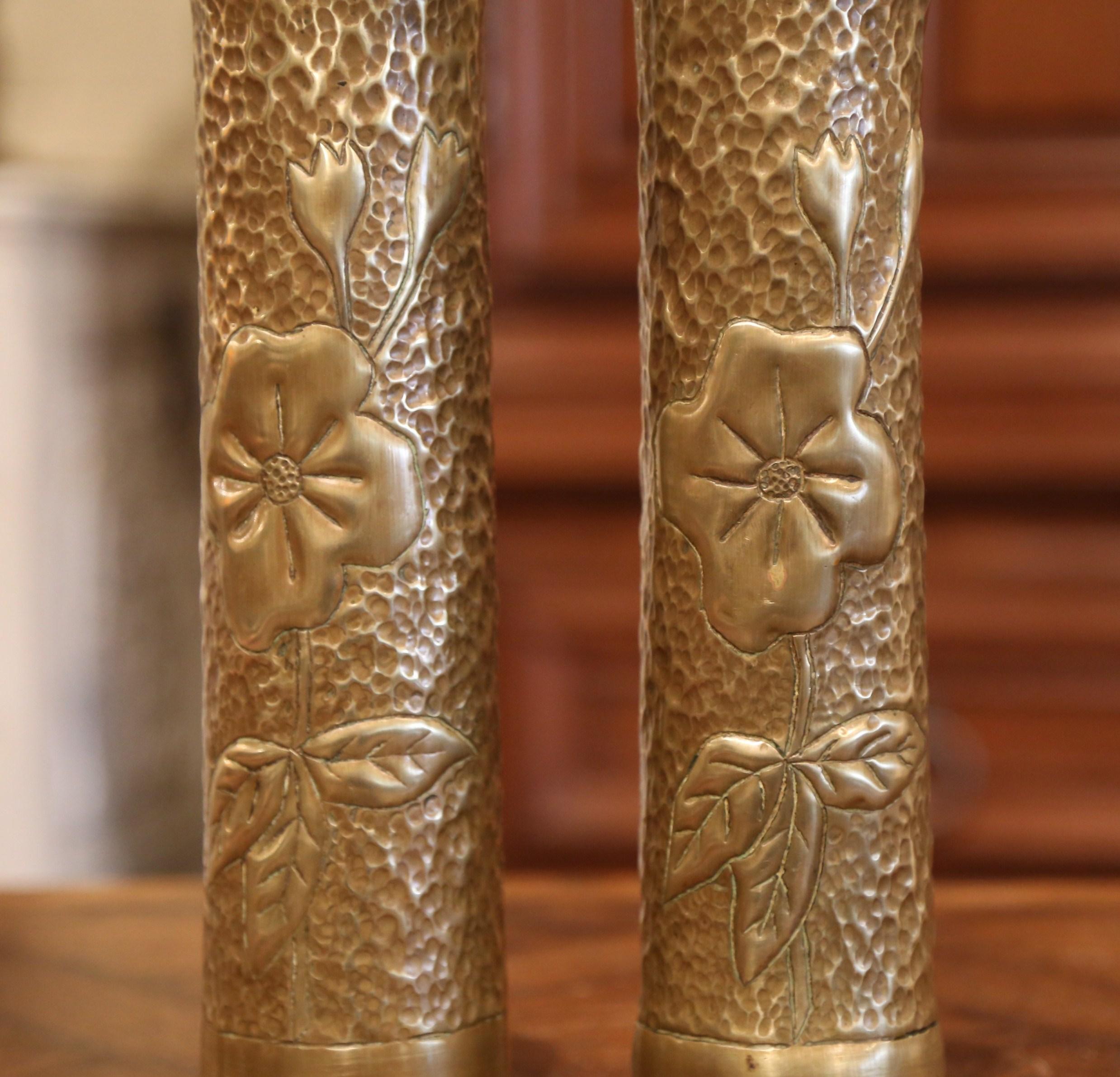 Decorate a table or a shelf with this pair of antique repousse trench art shell vases. Made of brass and dated on the bottom, 1916, the shell casing feature floral and leaf repousse decor. Both WWI pieces are in excellent condition with a rich