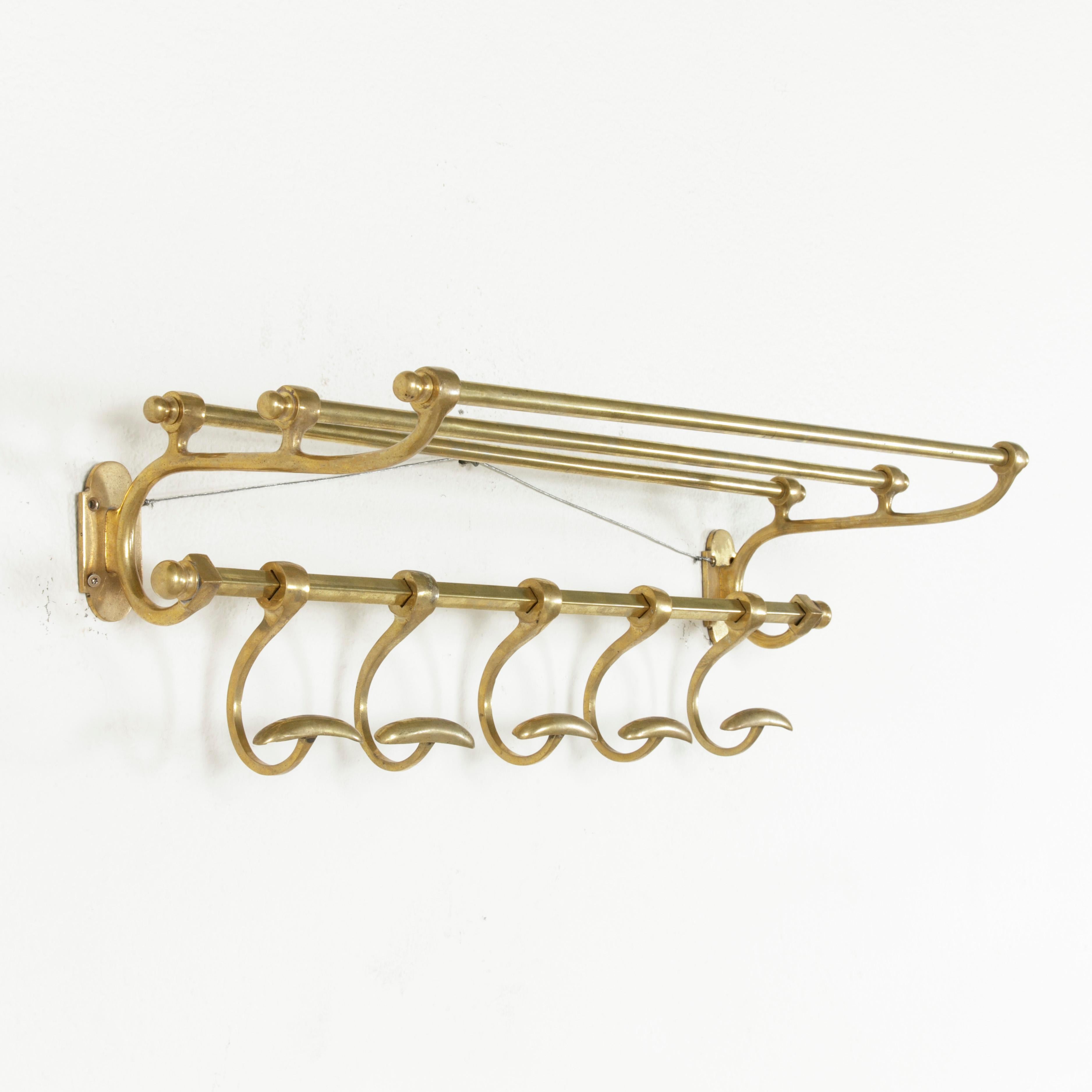 Originally form the cabin of a train, this early 20th century French hat and coat rack features an upper shelf and five sliding hooks. Its smaller scale of only 25.5 inches in width makes this piece ideal for hanging towels and robes in a bathroom,