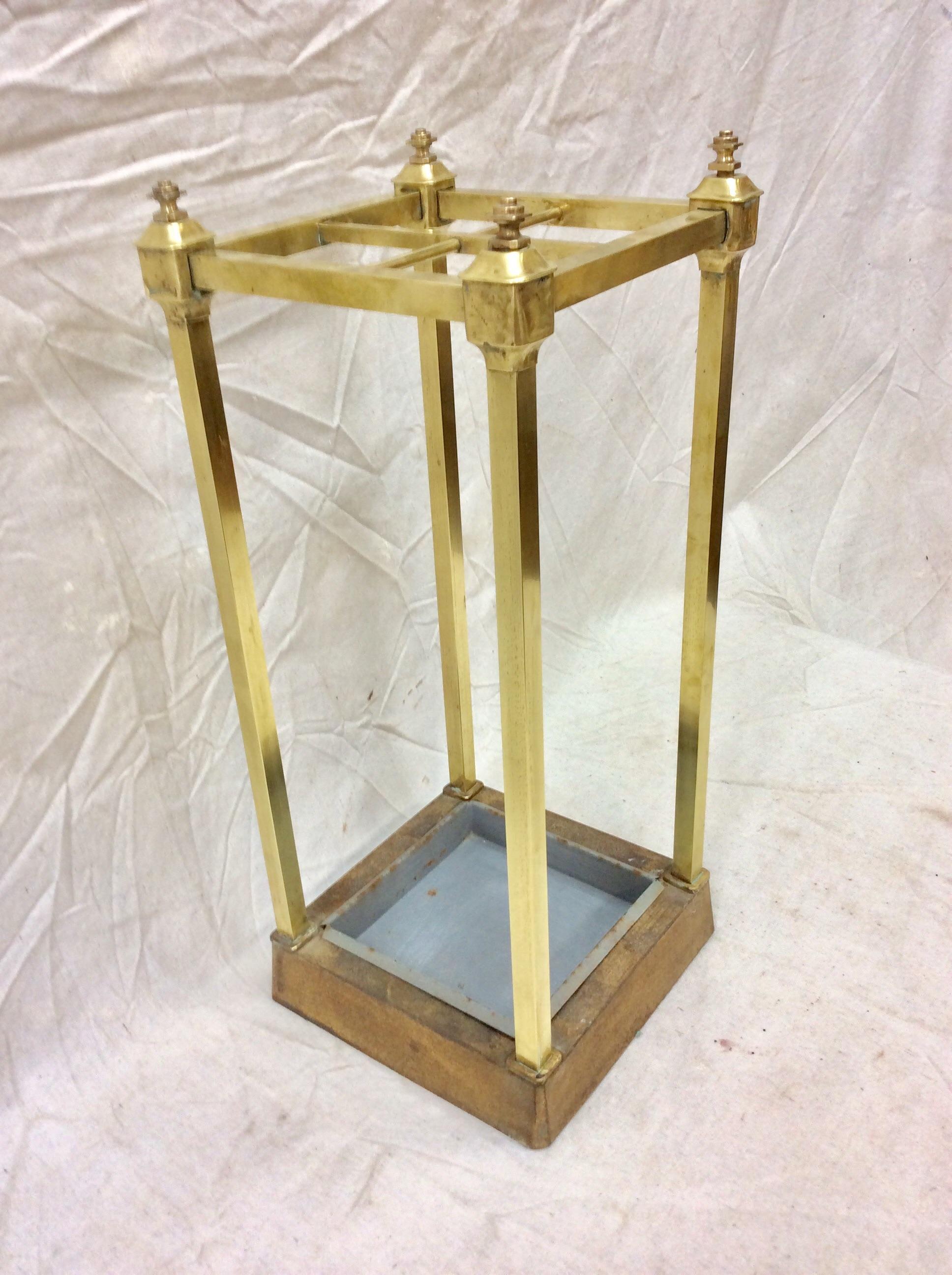 Found in the South of France, this Early 20th Century French Umbrella Stand features aged brass with four compartments to hold umbrellas or canes. Adorned with four brass finials the piece is weighted at the bottom with heavy metal and constructed
