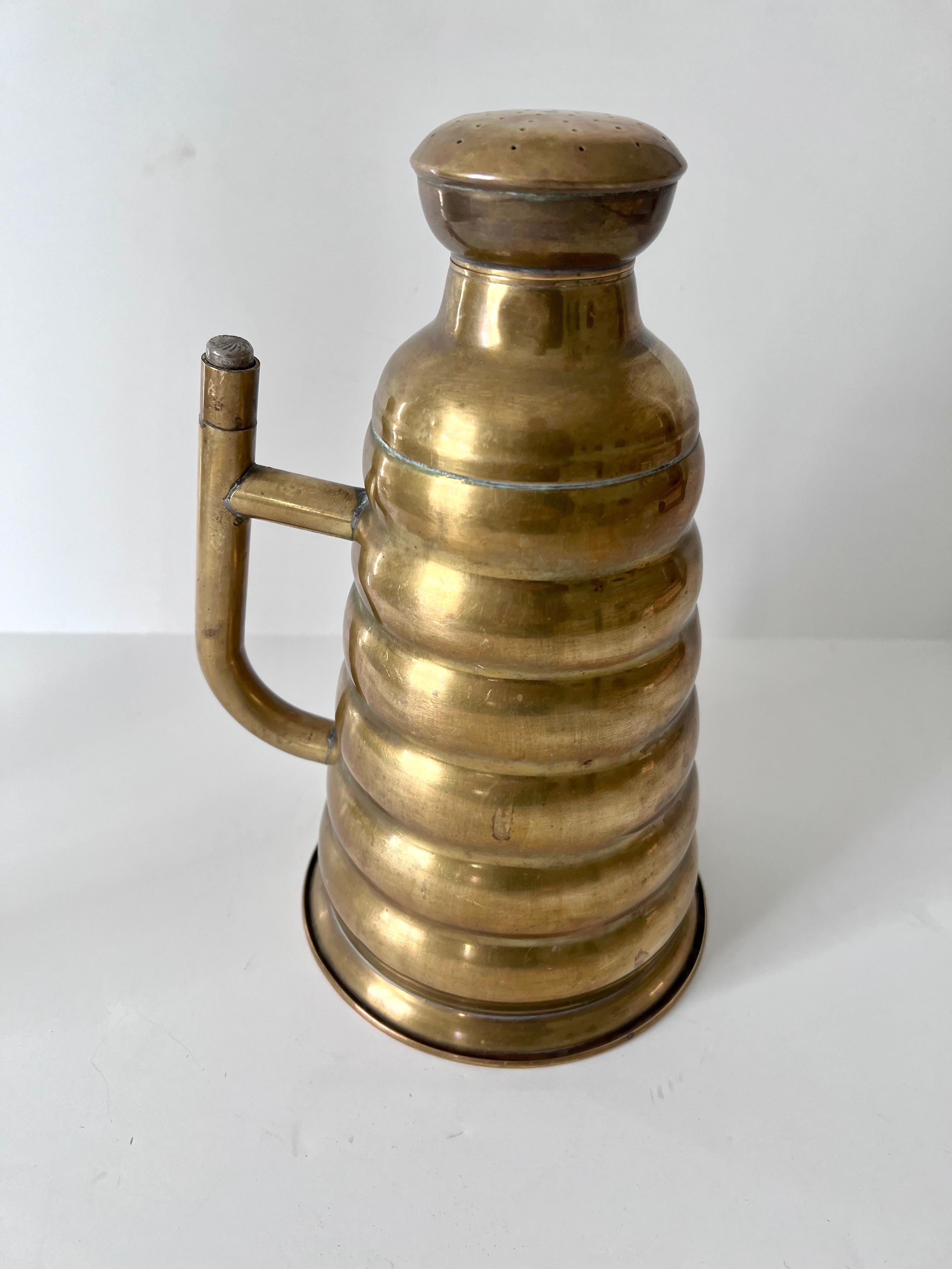 A very unique piece acquired in Paris France. The brass ribbed can with a handle is actually a can to sprinkle clothing when ironing, however it makes a great garden watering can, or also works beautifully as a stand-alone decorative piece.

A