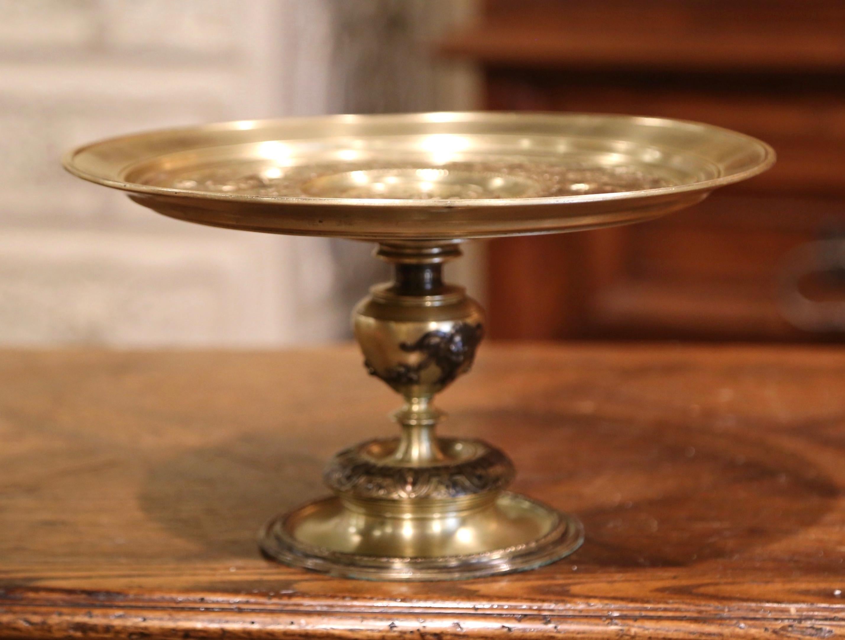 This elegant, antique bronze centerpiece was crafted in France, circa 1920. The shallow dish sits on an intricate round base; the top is decorated with traditional allegoric scenes and embellished with a central medallion featuring a lion figure