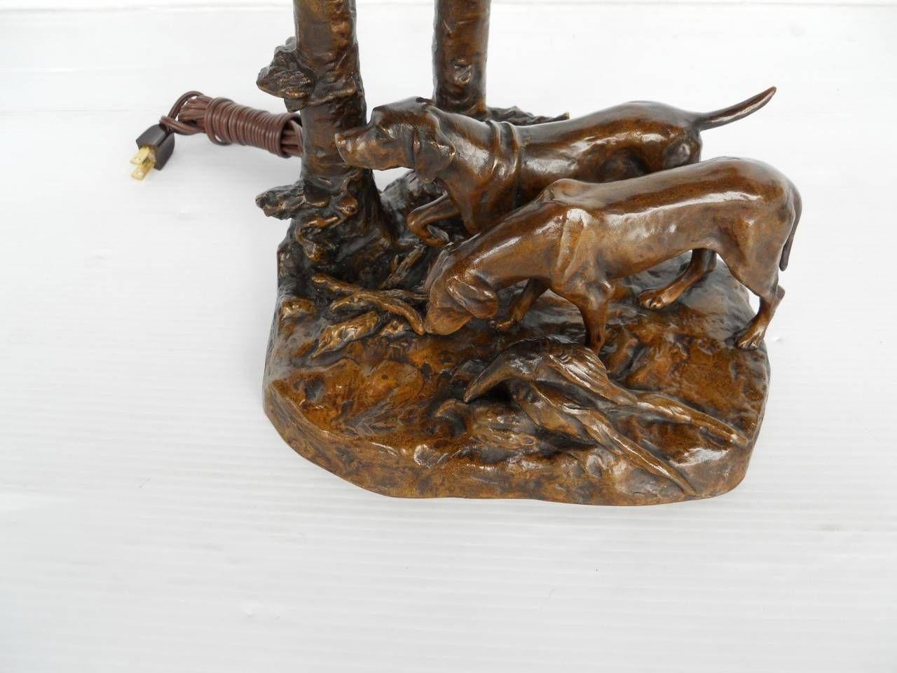 Französische Bronzelampe aus dem frühen 20. Jahrhundert von Frederich Gornik (signiert). Gekrönt von einem signierten Galle-Schirm, auf dem lila Mohnblumen abgebildet sind. Der Sockel zeigt eine sehr detaillierte Vignette mit zwei Jagdhunden, Wild
