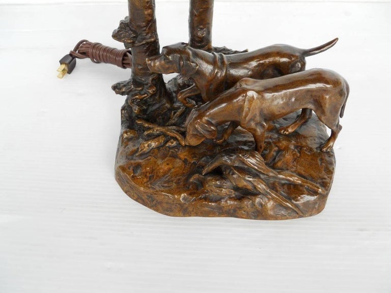 An early 20th C French bronze lamp by Frederich Gornik (signed). Topped with a signed Galle shade. depicting purple poppies. Base has a very detailed vignette of two hunting dogs, wild game and trees. Bronze is signed on the side 