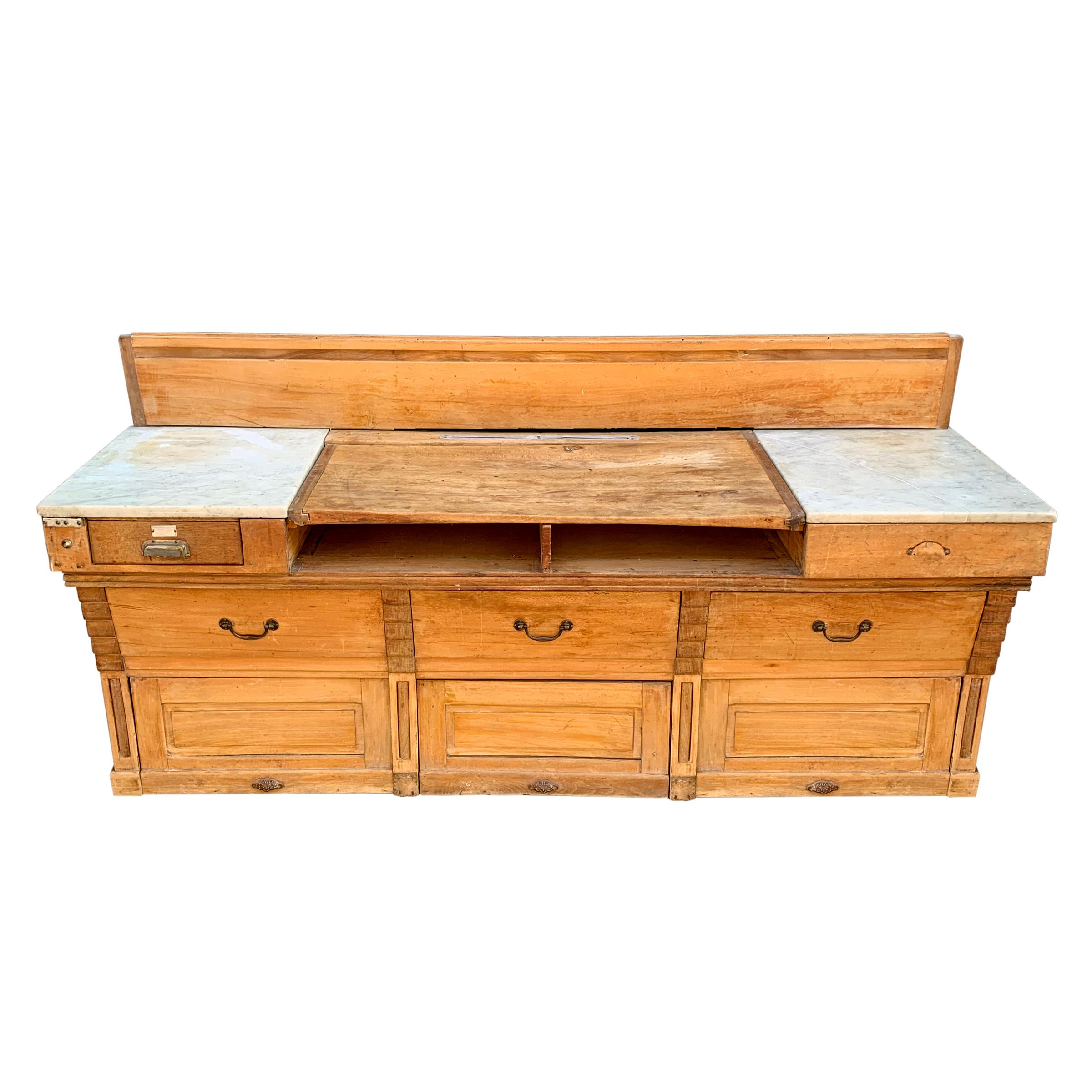 A wonderful early 20th century French butcher's block with a removable and reversible central cutting board flanked by two marble sides over three wide deep drawers and three storage compartments at the bottom. Would be incredible in a restaurant or