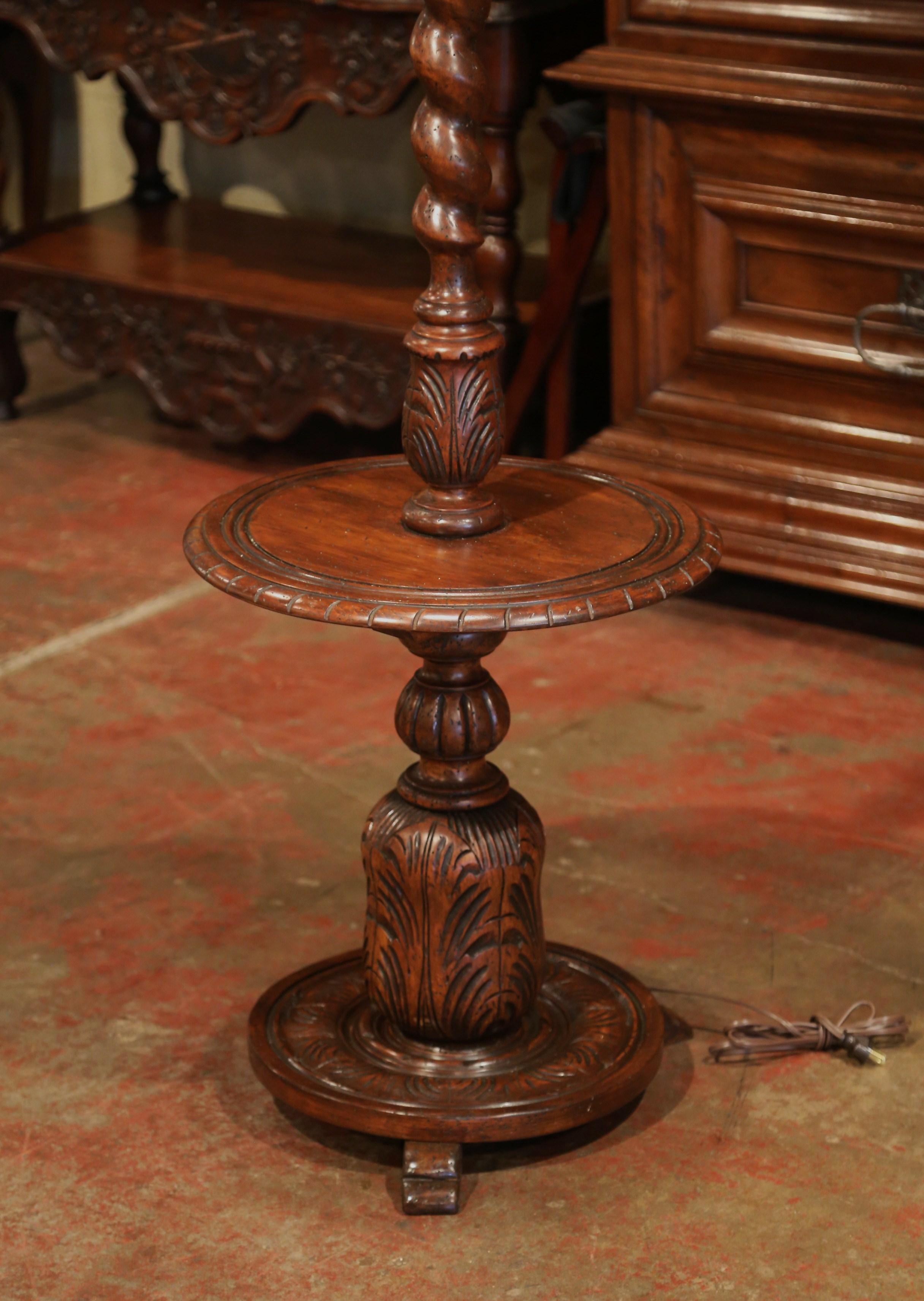 This unique, antique floor lamp was carved in Northern France, circa 1920. Seated on three small feet, the substantial, impressive walnut base features a barley twist stem, a round ledge in the center, and a carved base with intricate floral decor