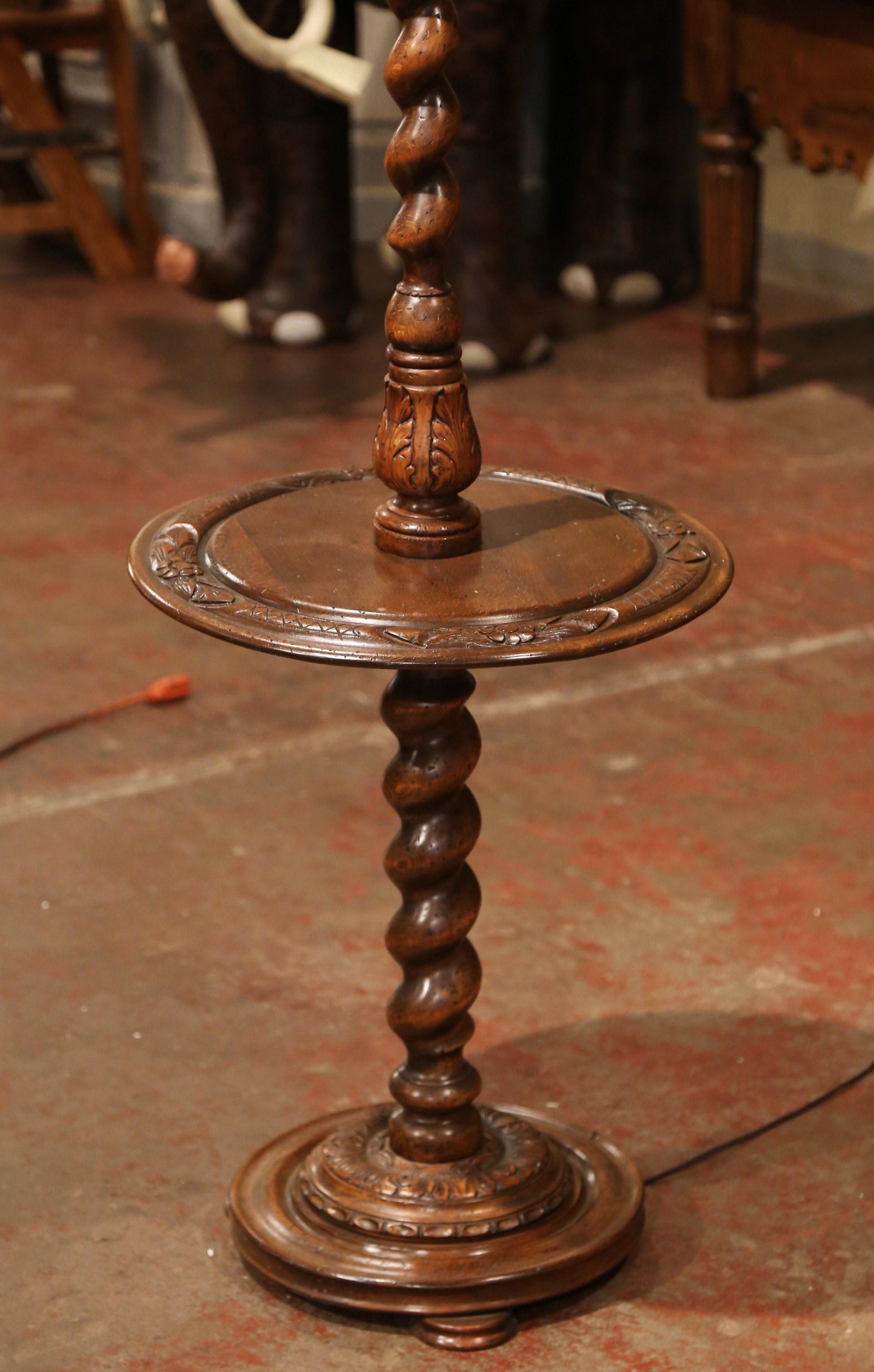 This unique, antique floor lamp was carved in Northern France, circa 1920. Seated on three small bun feet, the substantial, impressive walnut base features a barley twist stem, a round tabletop in the center with floral and acanthus leaf decor and a