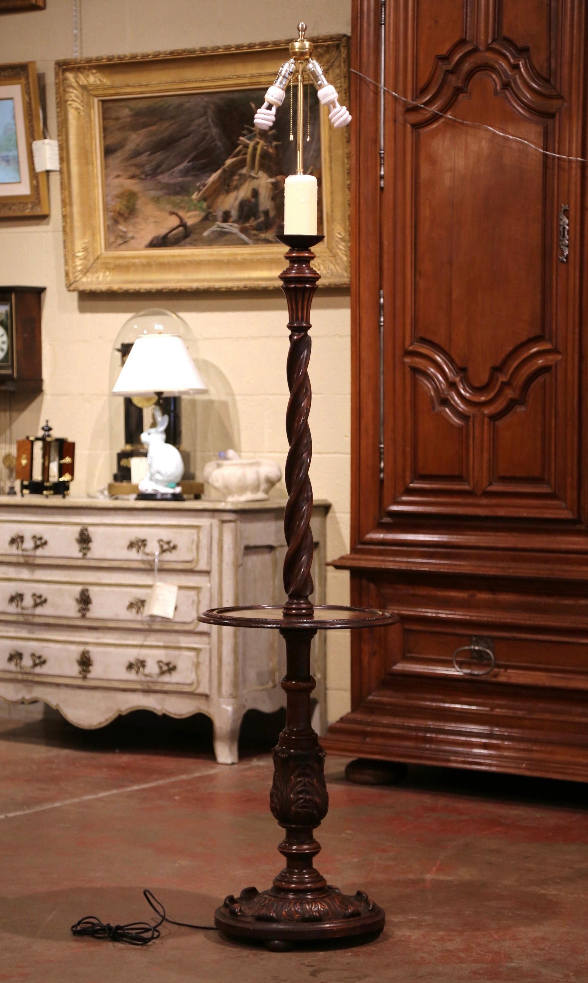 This unique, antique floor lamp was crafted in Northern France, circa 1920. Seated on three small feet over a circular base decorated with hand carved leaf motifs, the lamp features a barley twist stem embellished with acanthus leaf decor over a