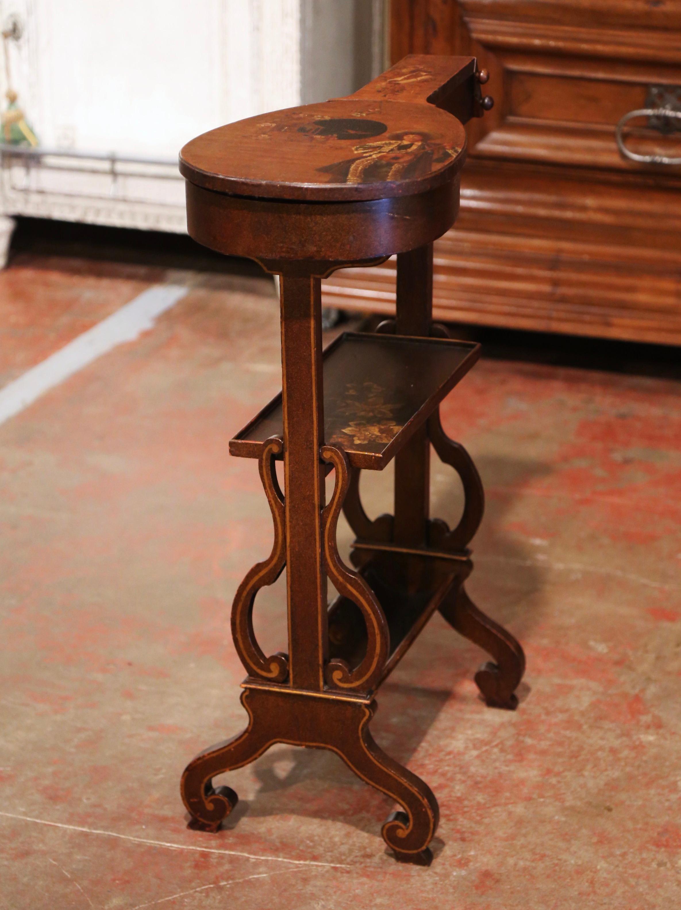 Decorate a study or music room with this elegant and unusual side table. Crafted in France circa 1940 and built of elm wood, the antique table stands on two trestle pedestal leg decorated with lyre motifs. The fruit wood top, shaped as a mandolin,