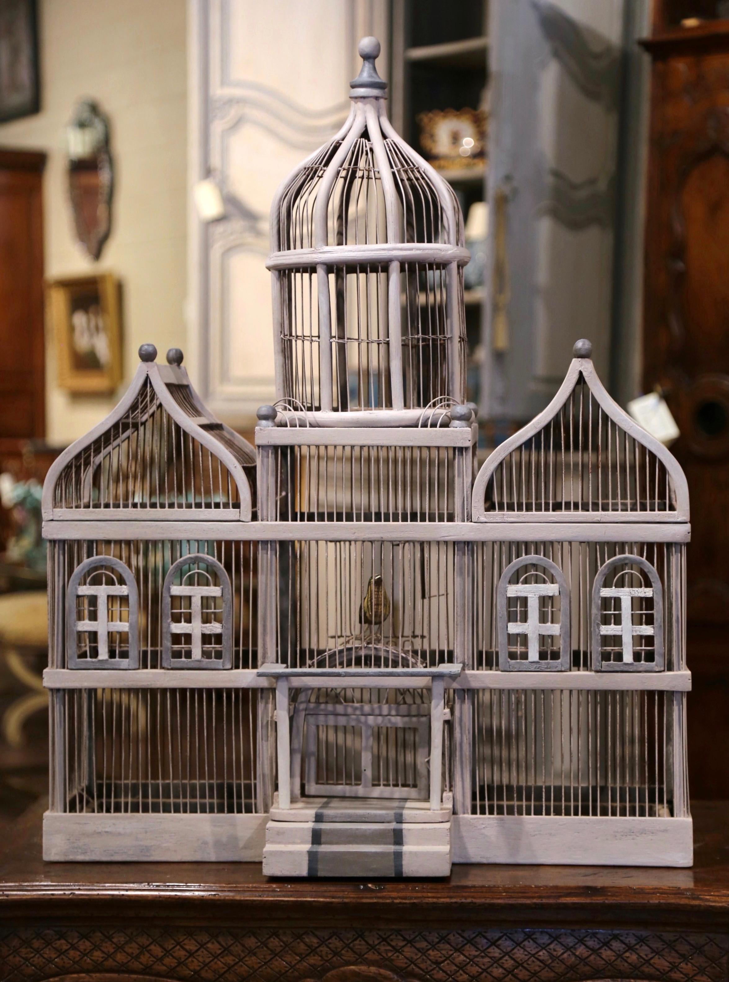 Bring the outdoors in with this large, elegant, antique birdcage. Crafted in France, circa 1920, this hand painted cage features three roofs including a central rounded dome embellished with a decorative finial at the pediment. The entire cage is
