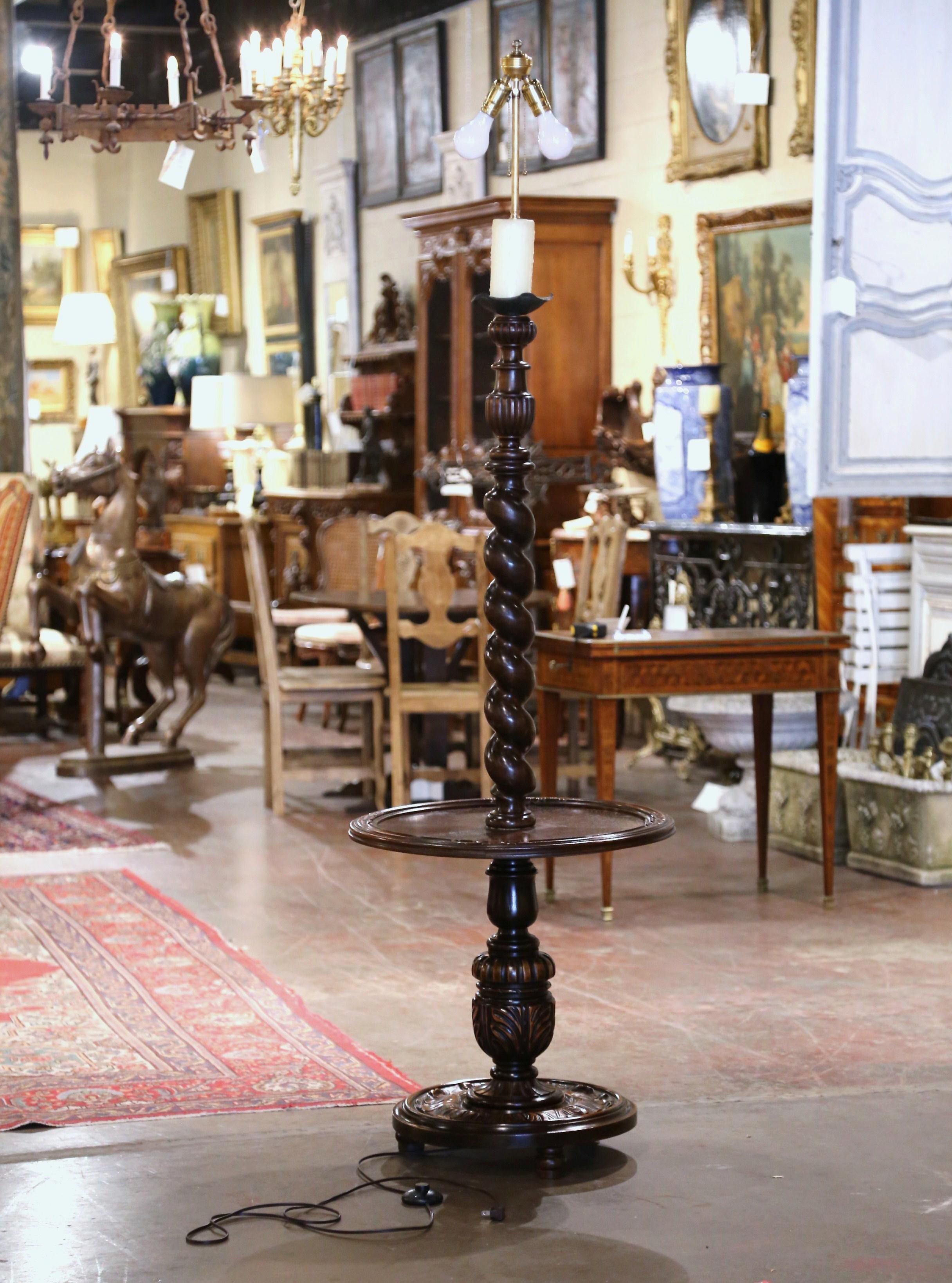 This unique, antique floor lamp was crafted in Northern France, circa 1930. Standing on three bun feet over a circular base embellished with foliage decor, this walnut lamp features a thick base decorated with acanthus leaf motifs. The lamp is