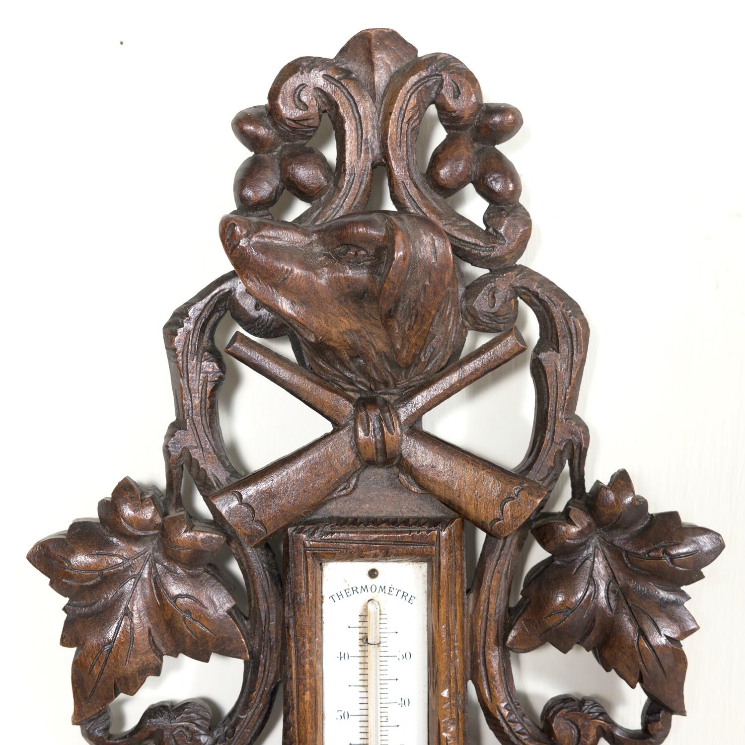 A stunning early 20th century French black forest barometer with thermometer, circa 1900. Found in a hunting lodge in Lyon, this antique weather station features a beautifully hand carved walnut frame presenting forest leaves and branches with a