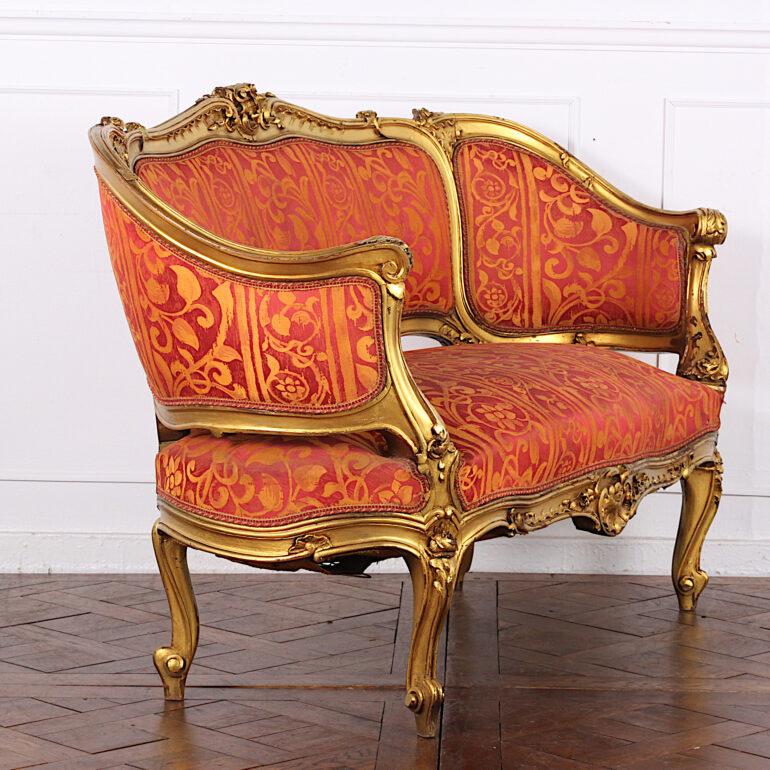 An early 20th century French-made carved and gilt Louis XV style 'canapé ' settee or sofa, the frame profusely embellished with carved foliage, shells, scrolls etc.
 
  