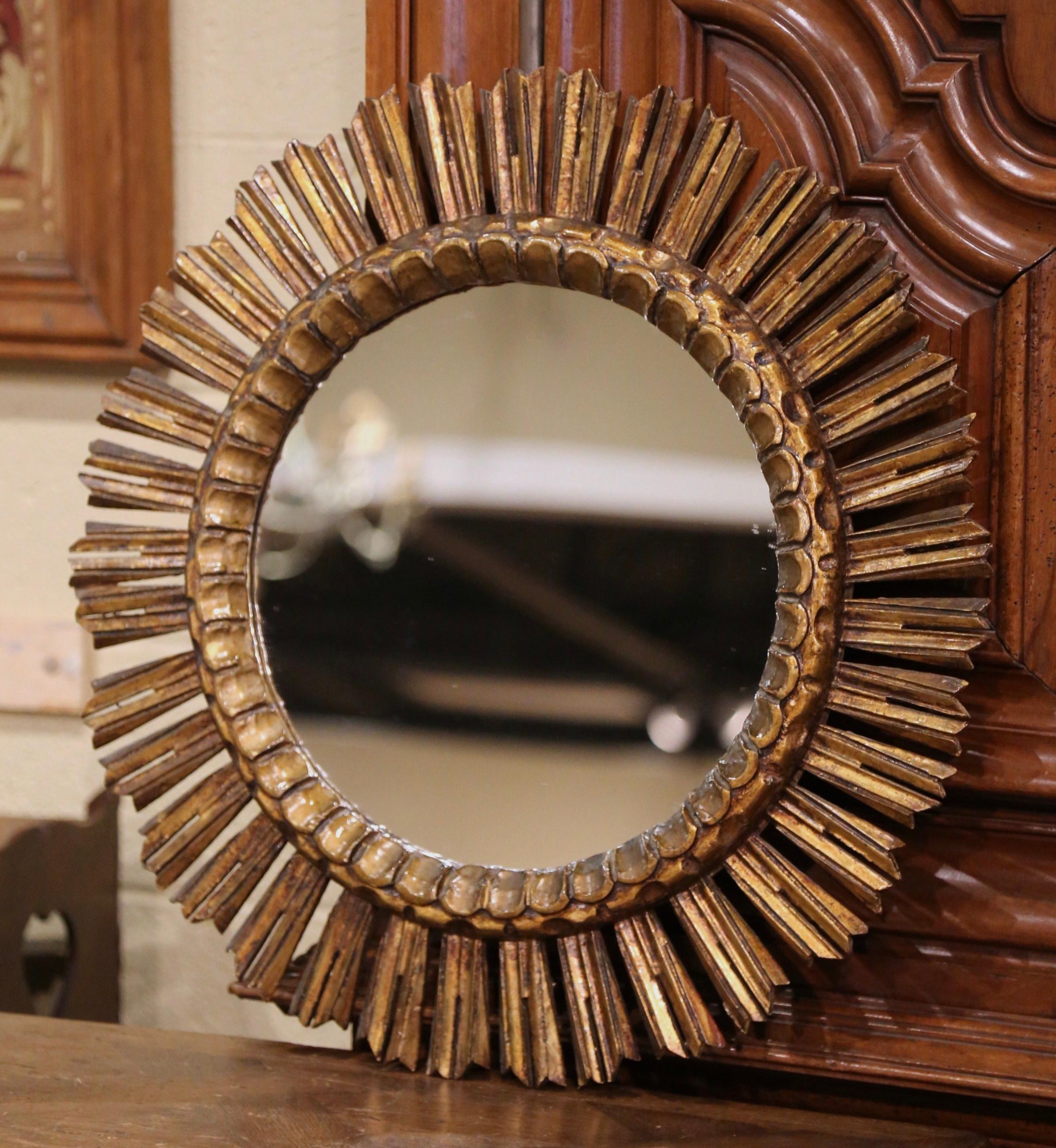 Incorporate extra light into any room with this large vintage sun mirror. Crafted in France, circa 1930 and round in shape, the decorative mirror has intricate carvings throughout and resembles the shape and shine of the sun. The sunburst mirror is