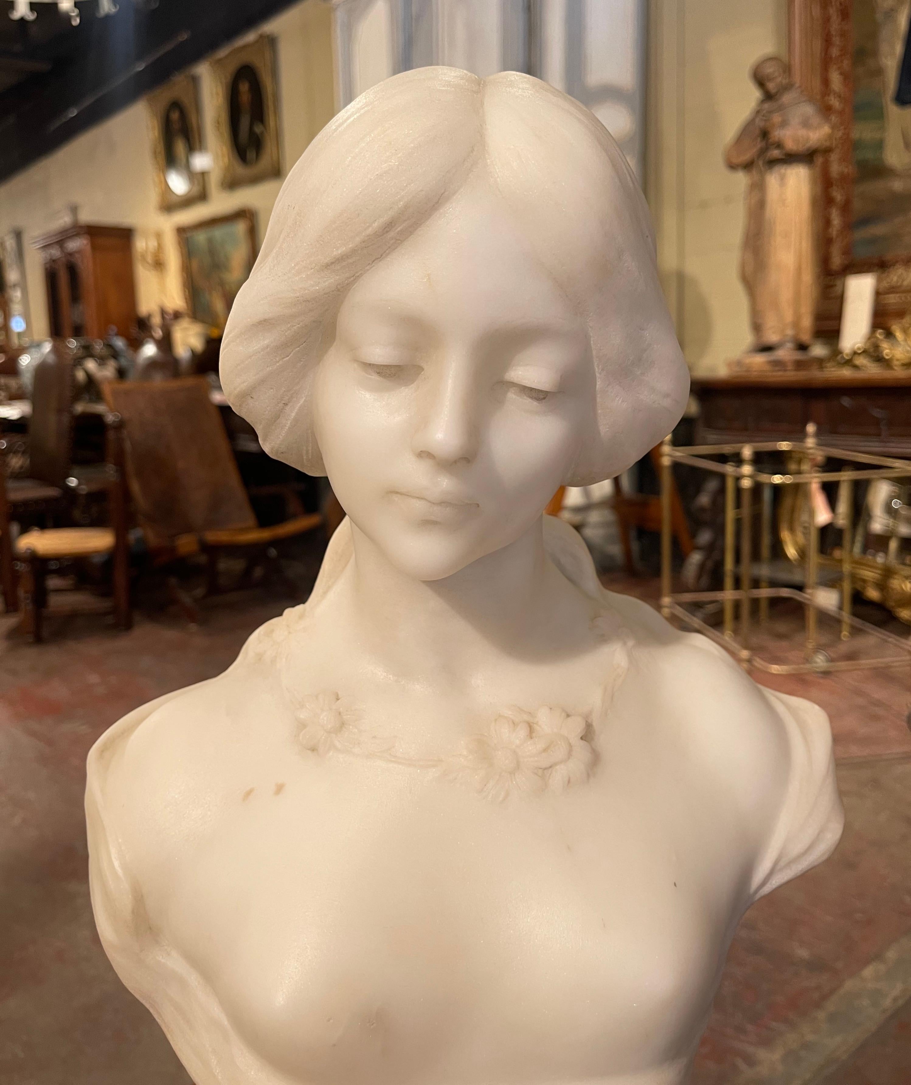 Crafted in France circa 1920, this two-piece white marble bust on a quartz base is a true representation of French elegance. The figural sculpture features the visage of a beautiful, young girl in a lace dress with delicately posed hands. There are