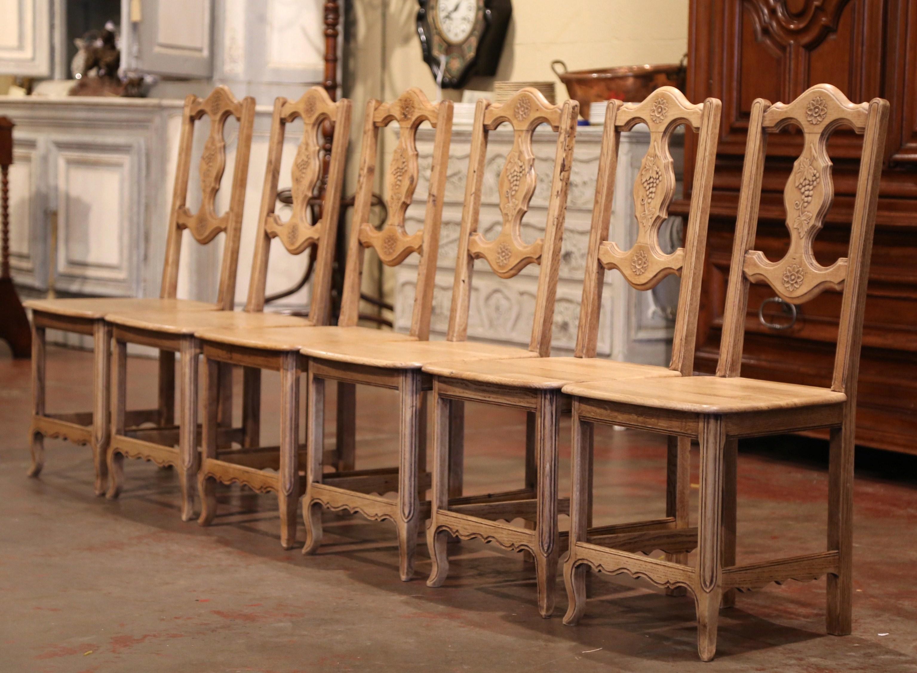 Dekorieren Sie einen Weinkeller oder einen Frühstücksraum mit dieser eleganten Sitzgruppe aus antiken Stühlen mit Leiterlehne. Die um 1920 in Frankreich gefertigten Beistellstühle aus Eichenholz stehen auf geraden Beinen mit Schnörkelfüßen über