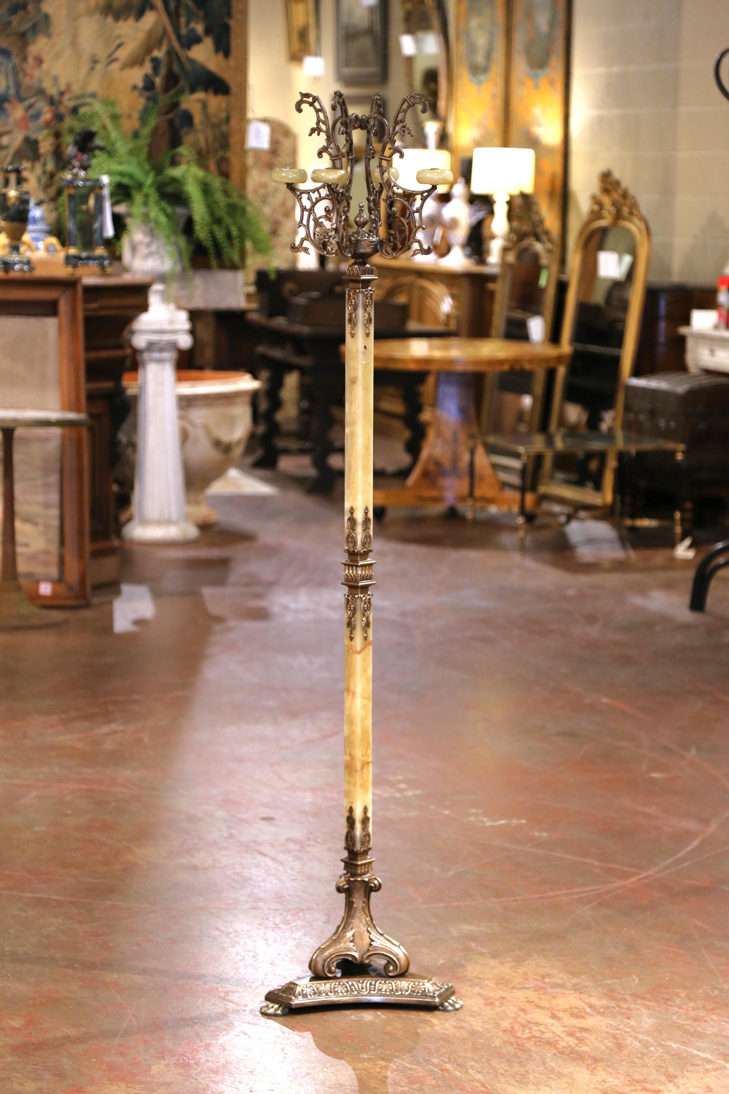 Questo antico albero da ingresso in onice e ottone intagliato è stato realizzato in Francia, intorno al 1920. Poggiato su un'intricata base triangolare modellata che termina con piedi a zampa, l'alto scaffale presenta uno stelo centrale quadrato in