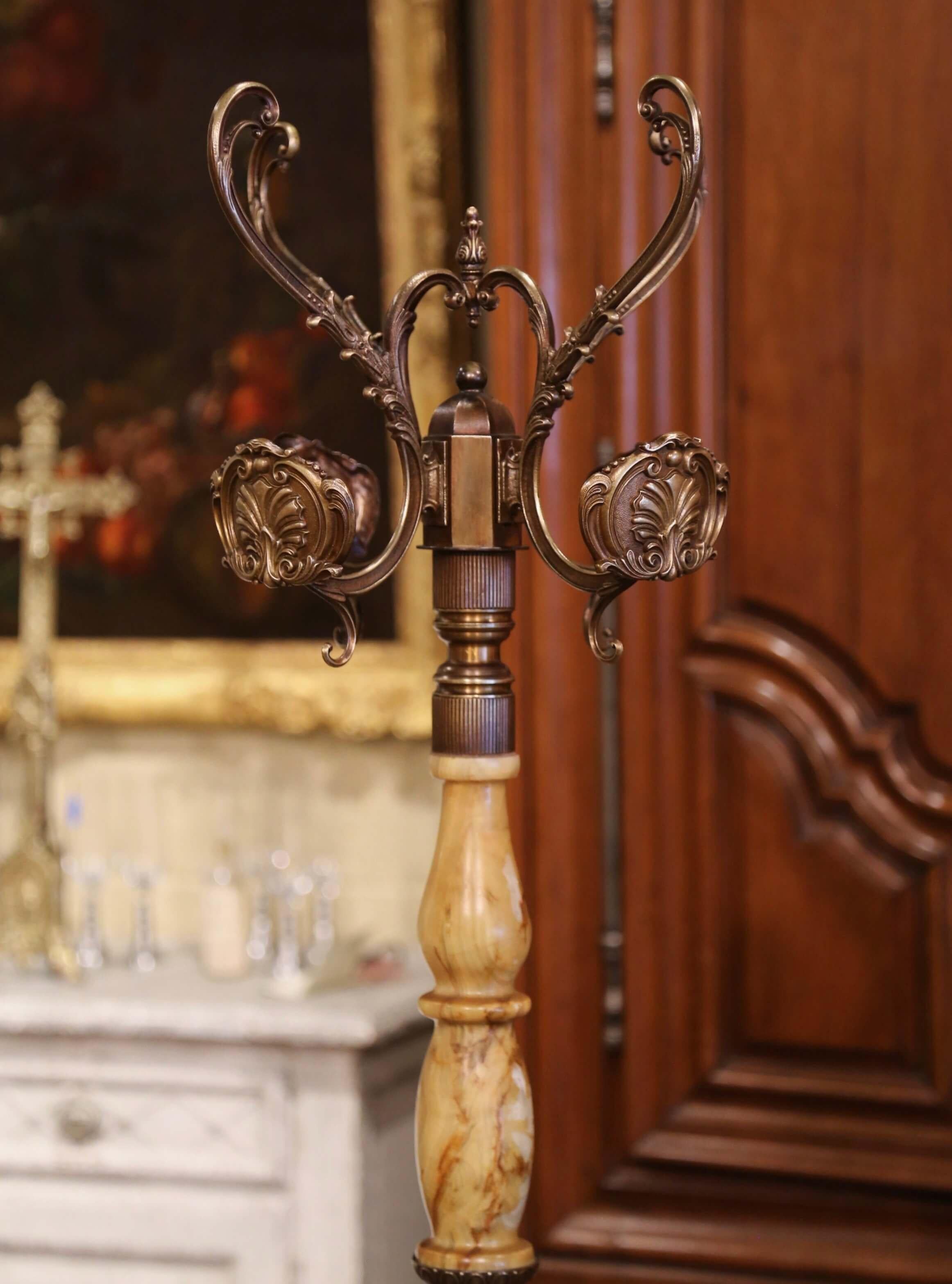 This antique carved onyx and brass hall tree was crafted in France, circa 1920. Standing on an intricate vasiform base ending in quadri-partite feet with dolphin form and acanthus leaf motifs, the tall rack features a turned spiral central onyx stem